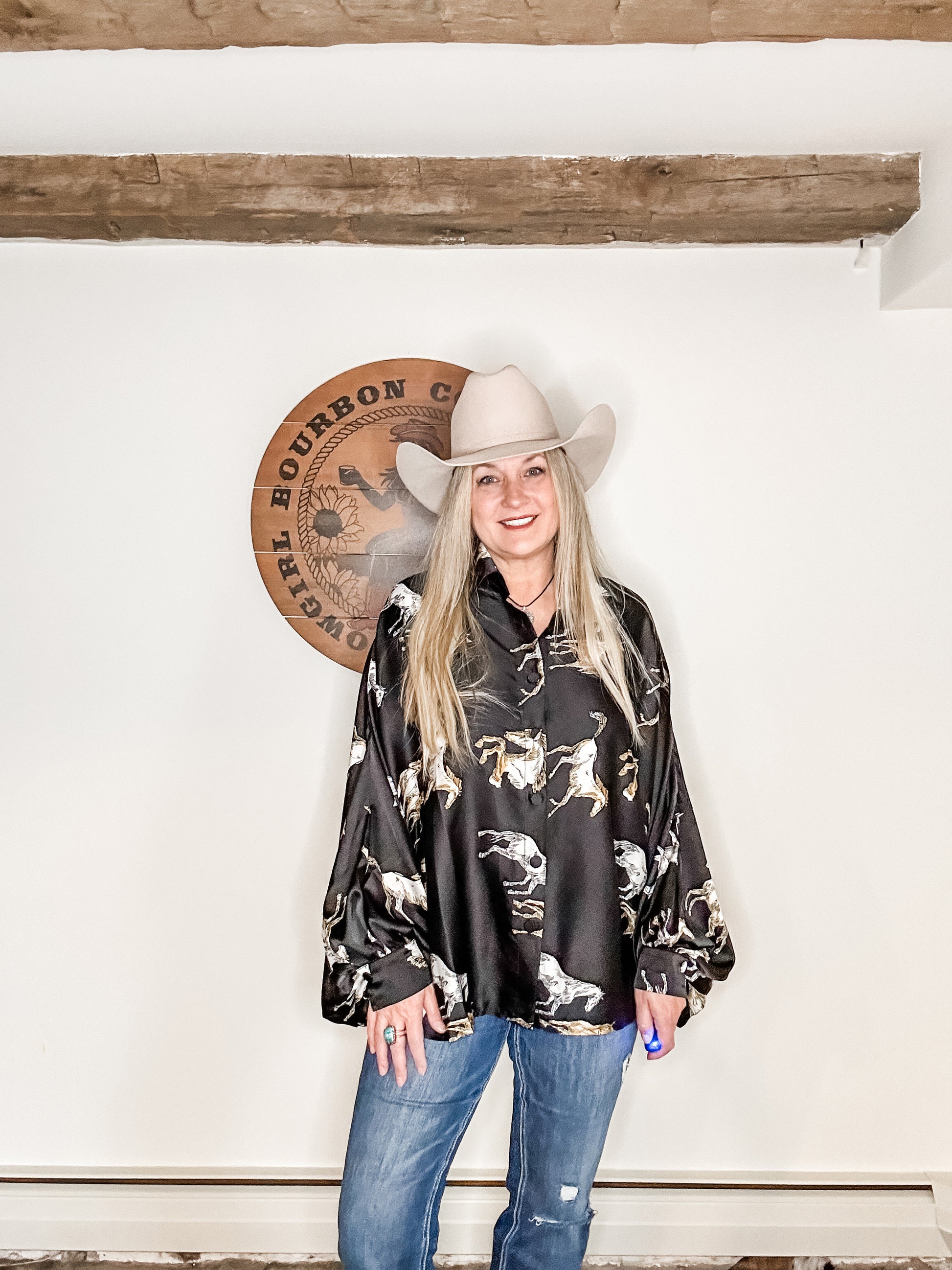 Woman in cowboy hat and printed blouse.