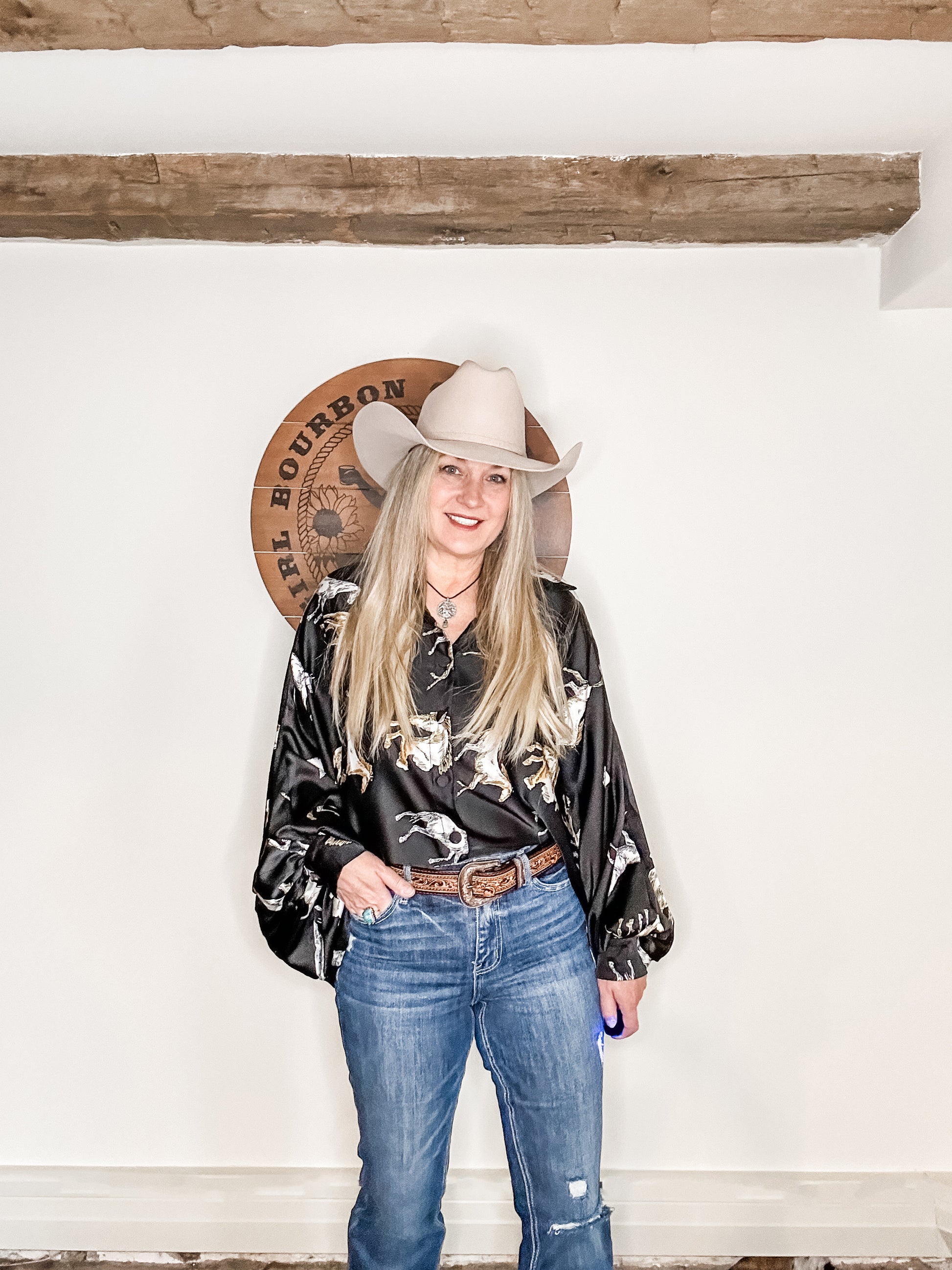 Woman in cowboy hat and patterned shirt.
