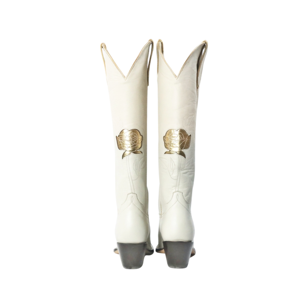 Pair of white cowboy boots with gold accents.