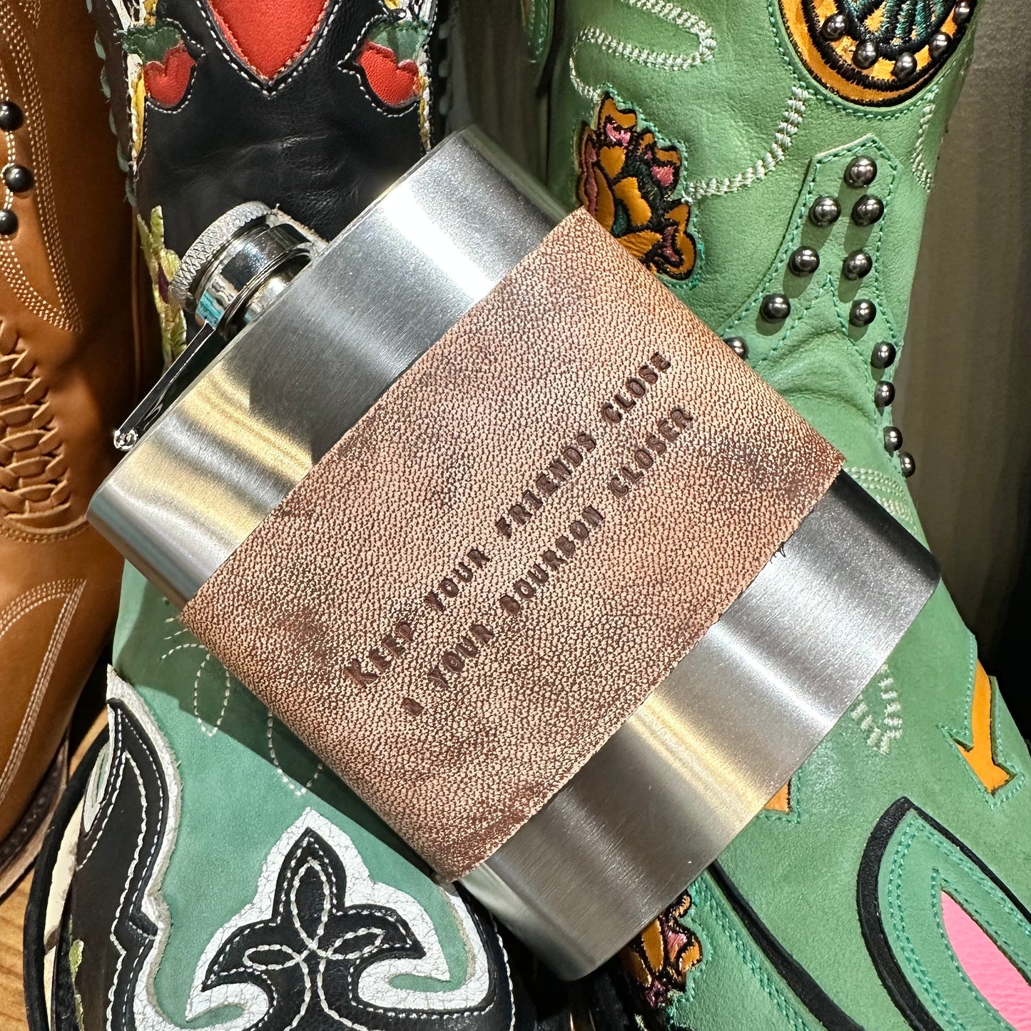 Flask with leather band and cowboy boots.