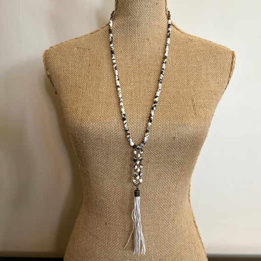 Beaded necklace with tassel on a mannequin.