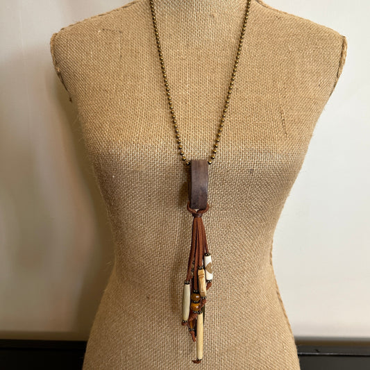 Mannequin wearing long pendant necklace.