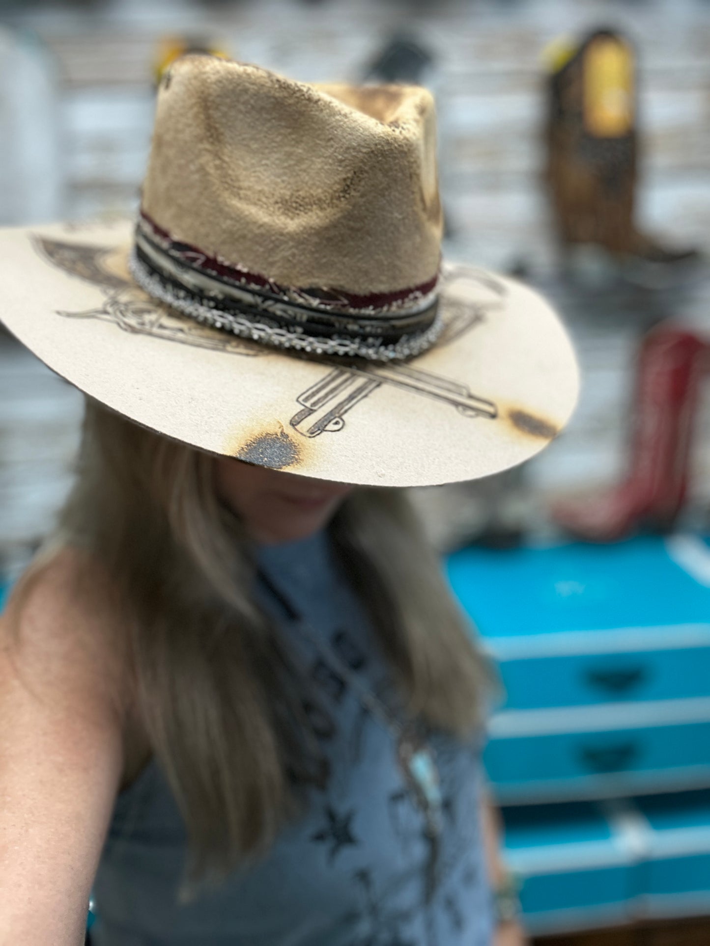 Woman wearing a tan cowboy hat with decorative brim.