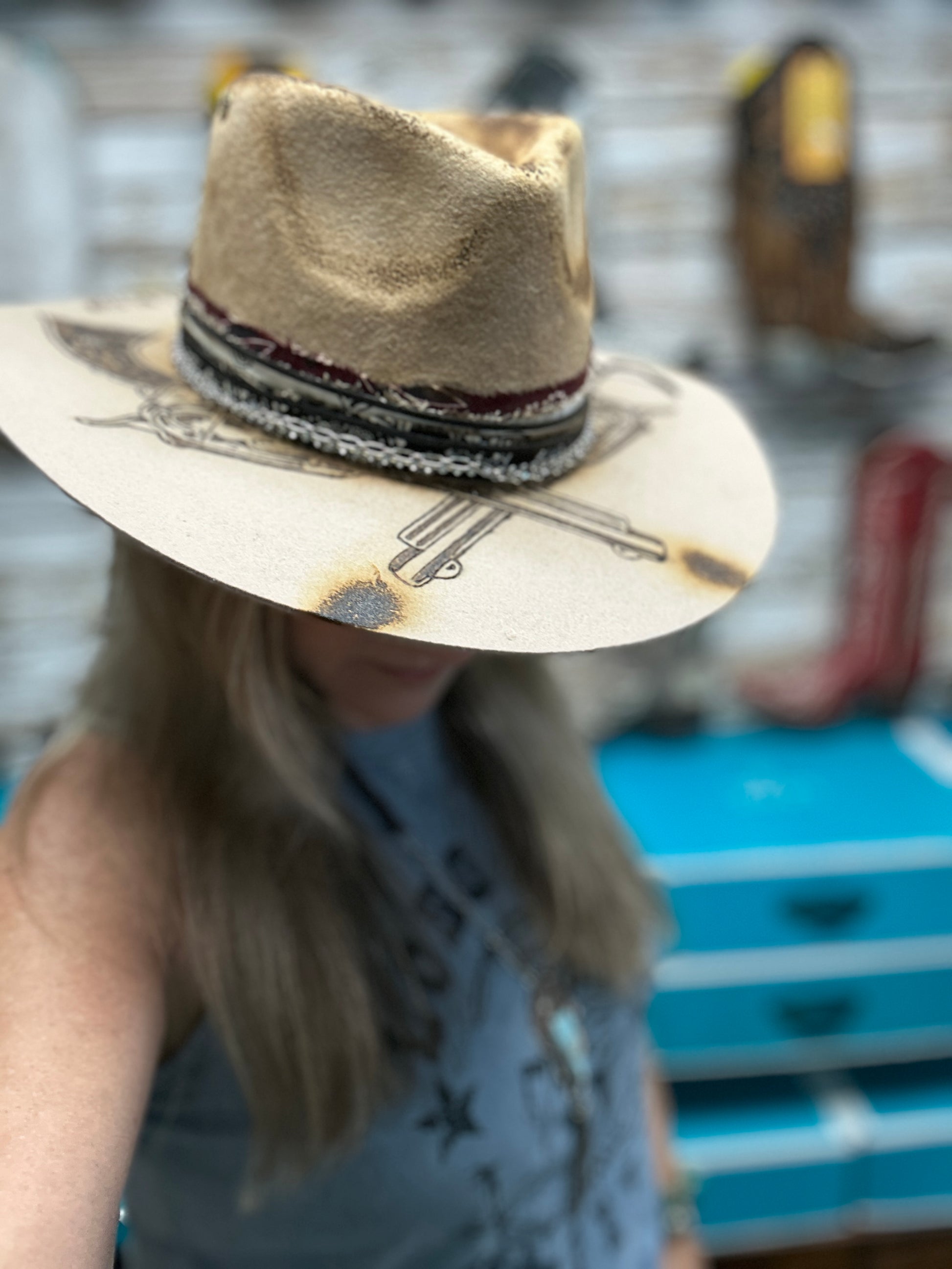 Woman wearing a tan cowboy hat with decorative brim.