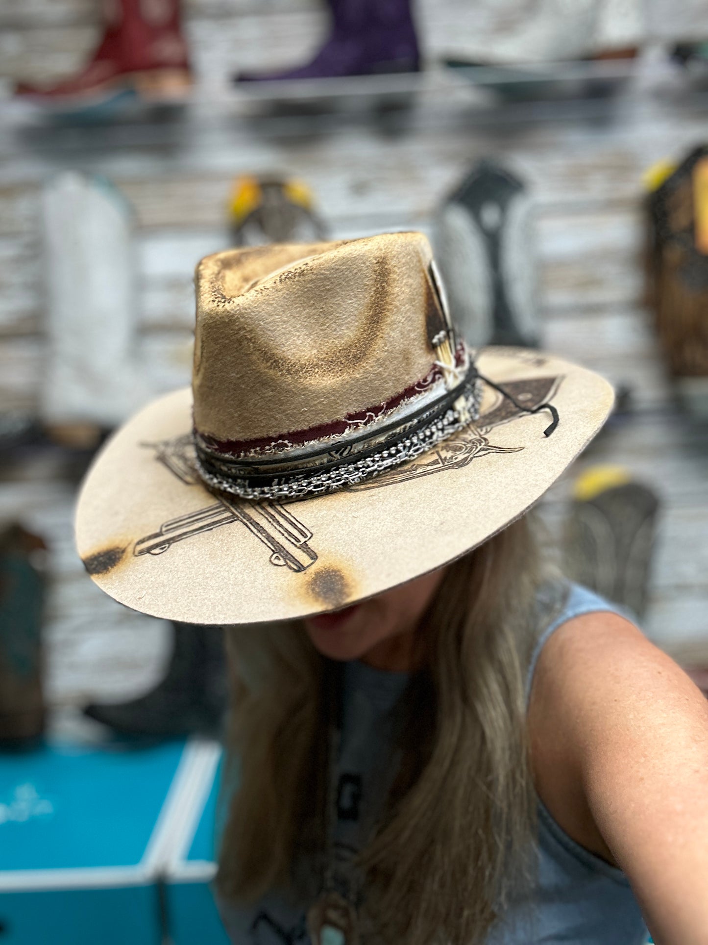 Woman wearing a tan cowboy hat with decorative brim.