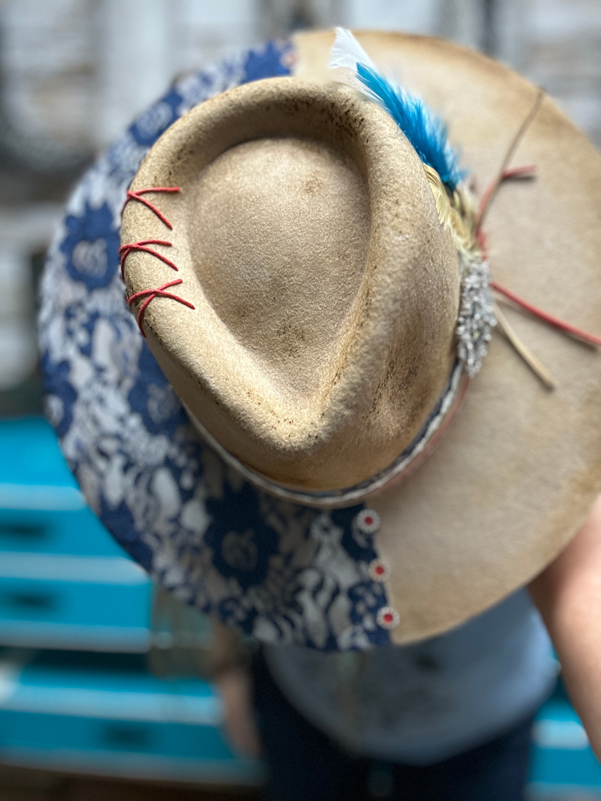 Tan and blue floral hat with feather.