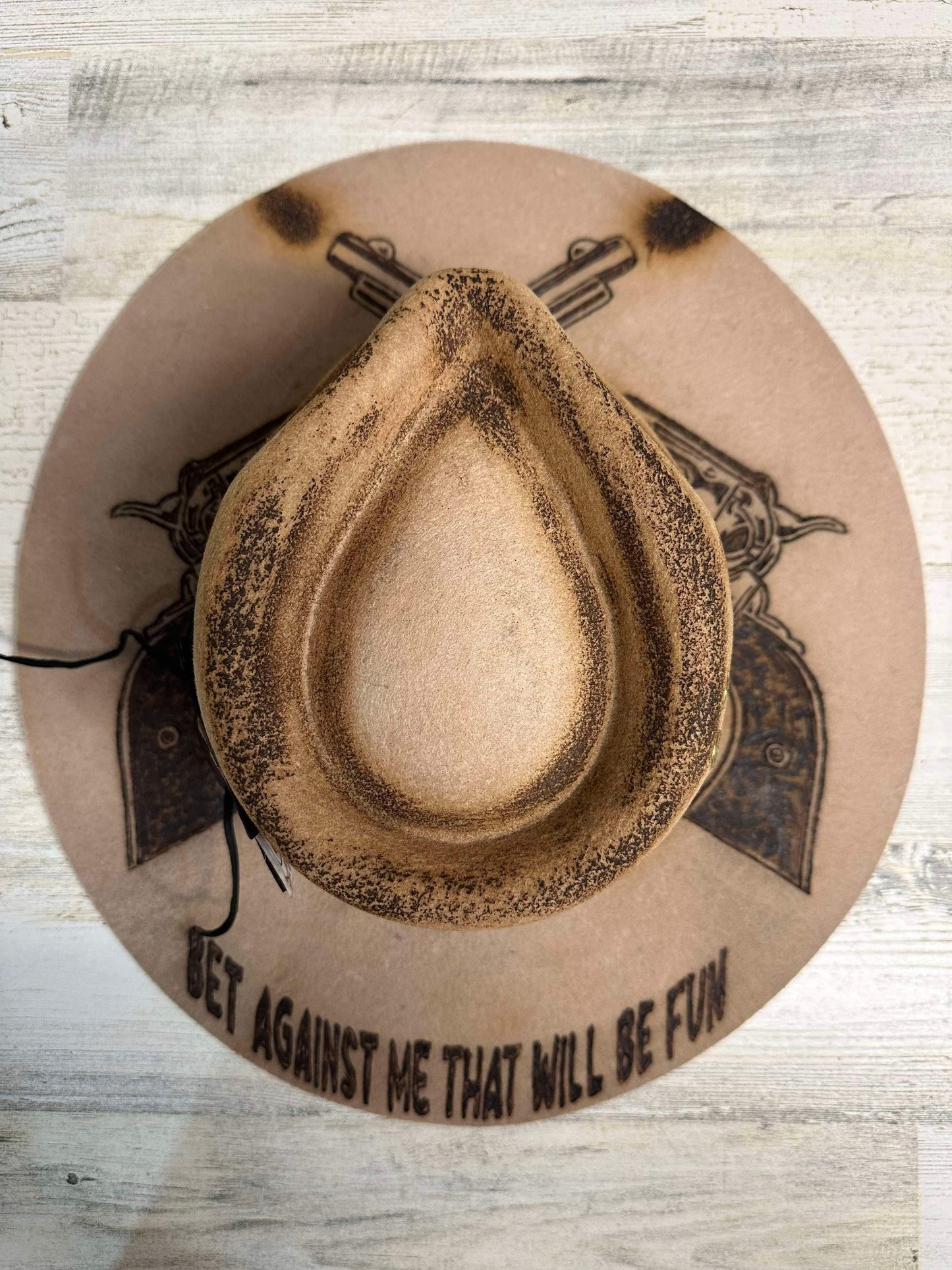 Cowboy hat with crossed pistols design.