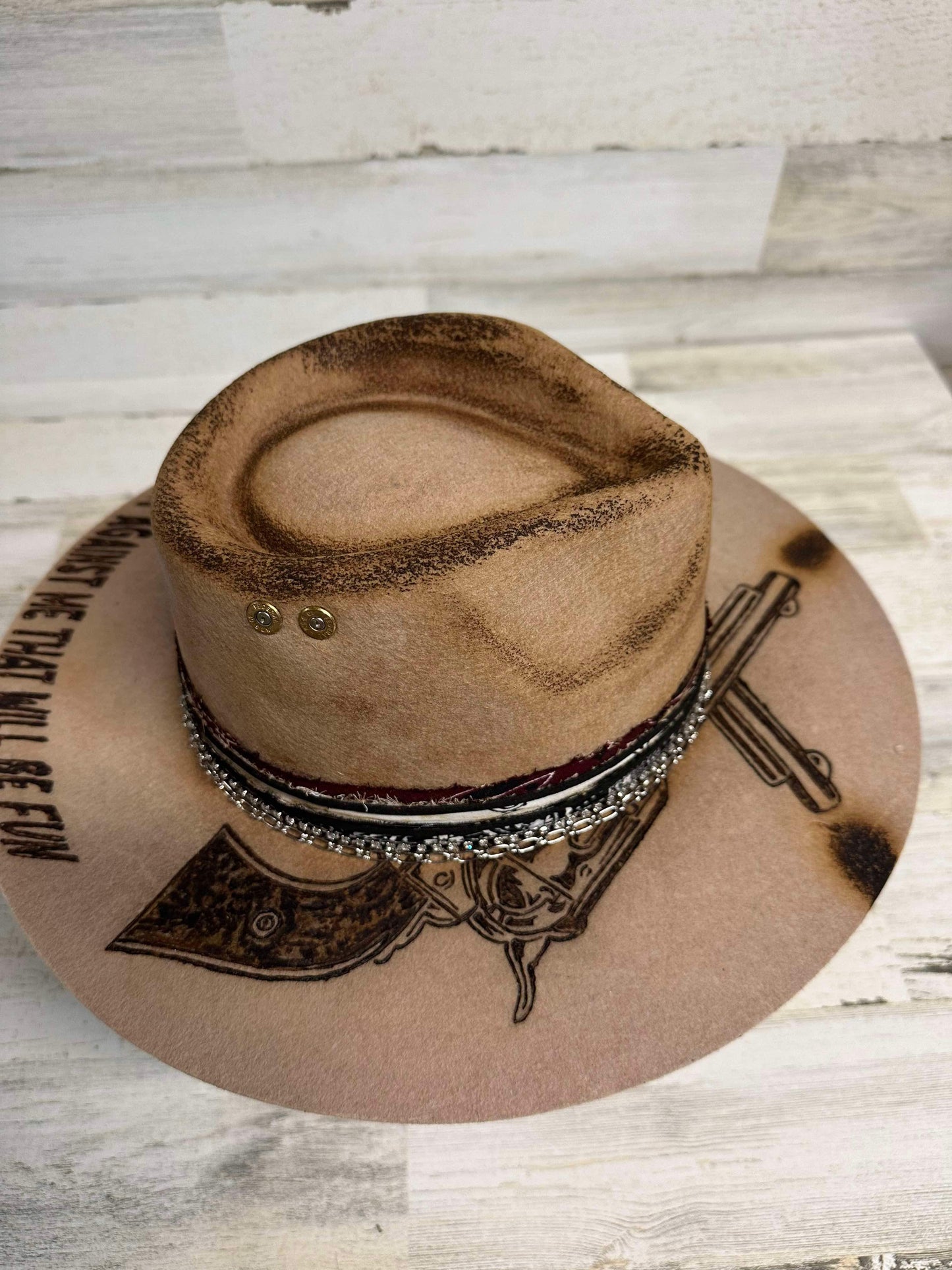Tan cowboy hat with gun design.