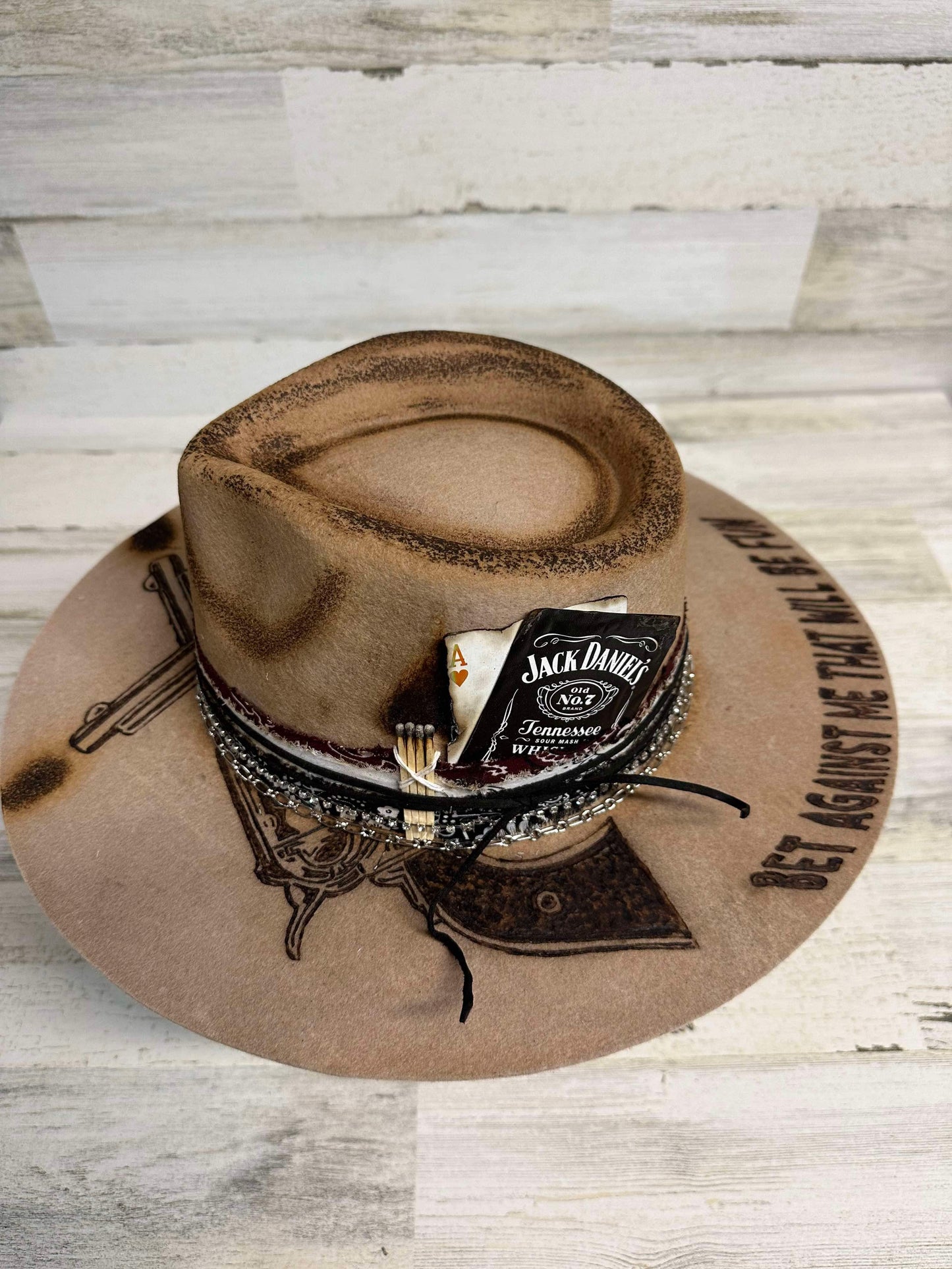 Brown cowboy hat with Jack Daniel's label and gun design.