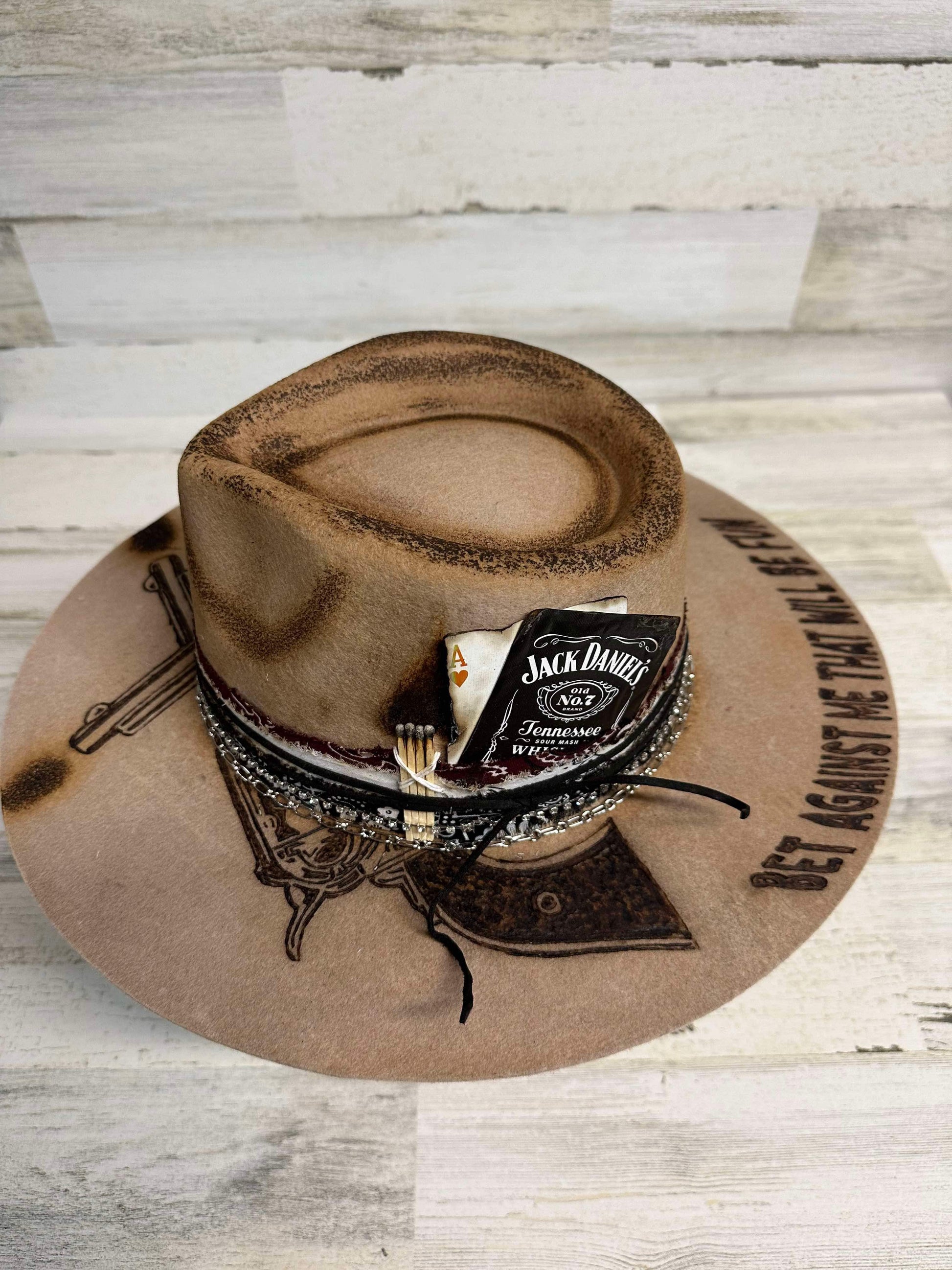Brown cowboy hat with Jack Daniel's label and gun design.