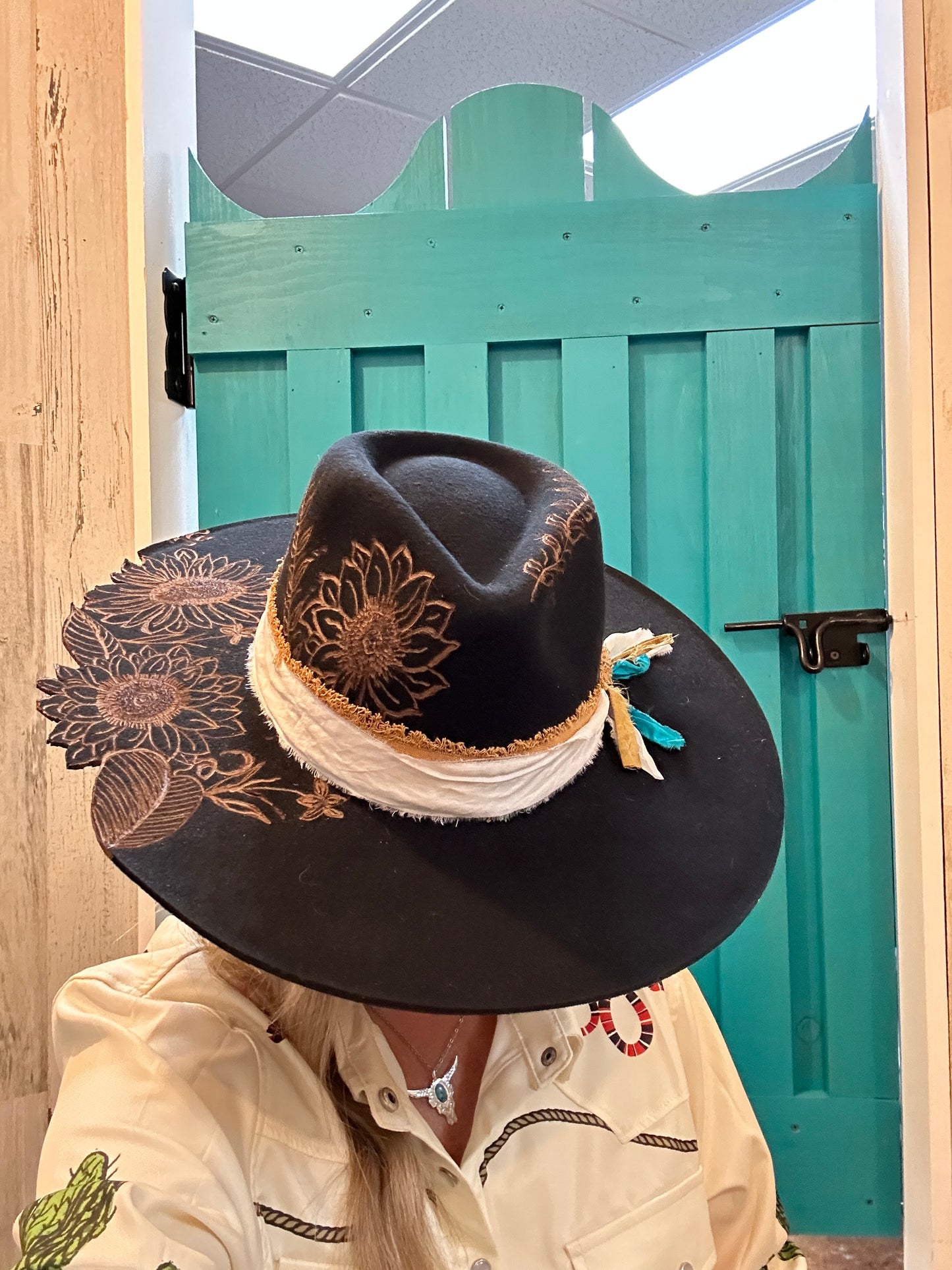 Black hat with sunflower design and white trim.