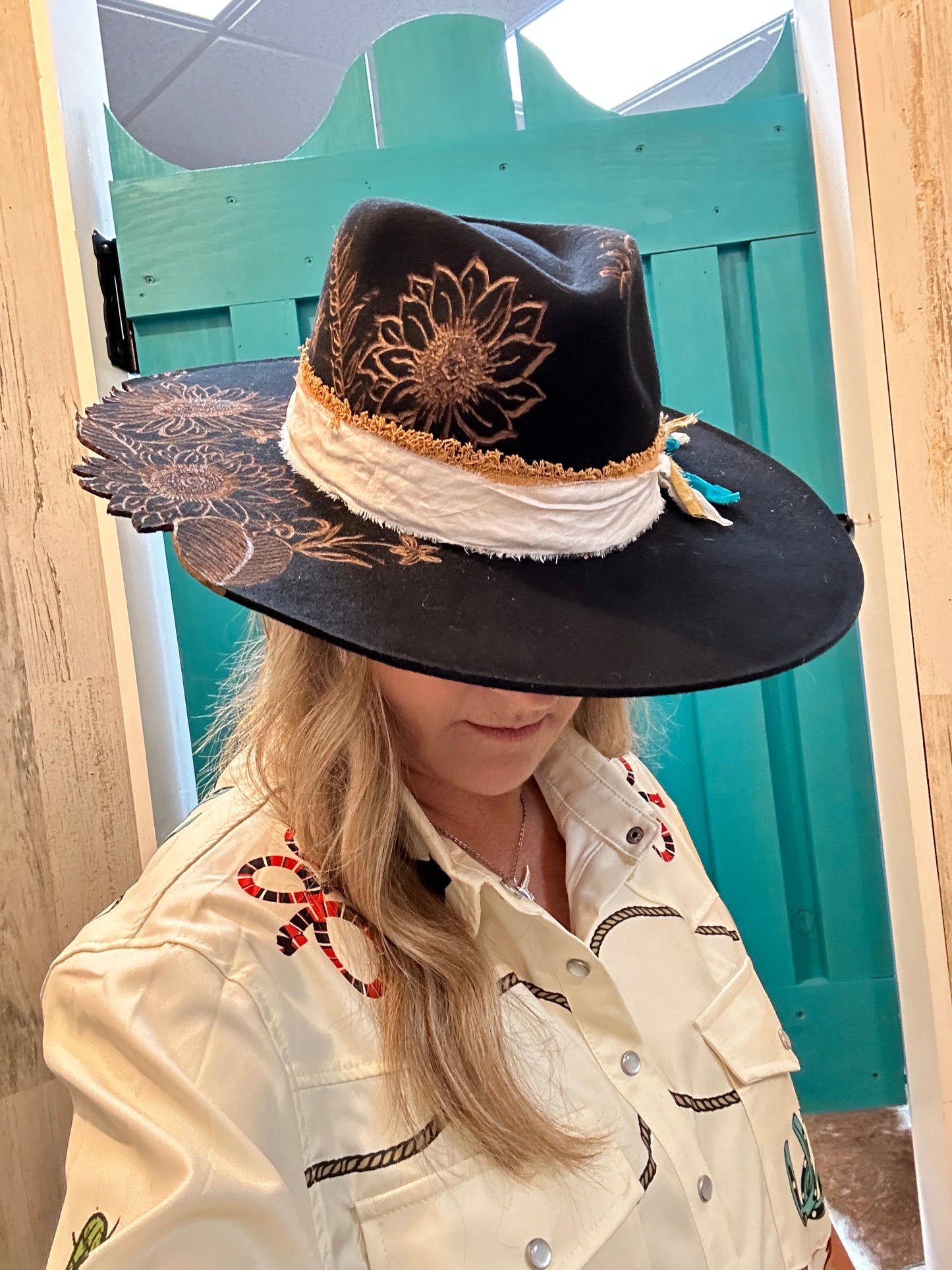 Woman wearing a black hat with a sunflower design.
