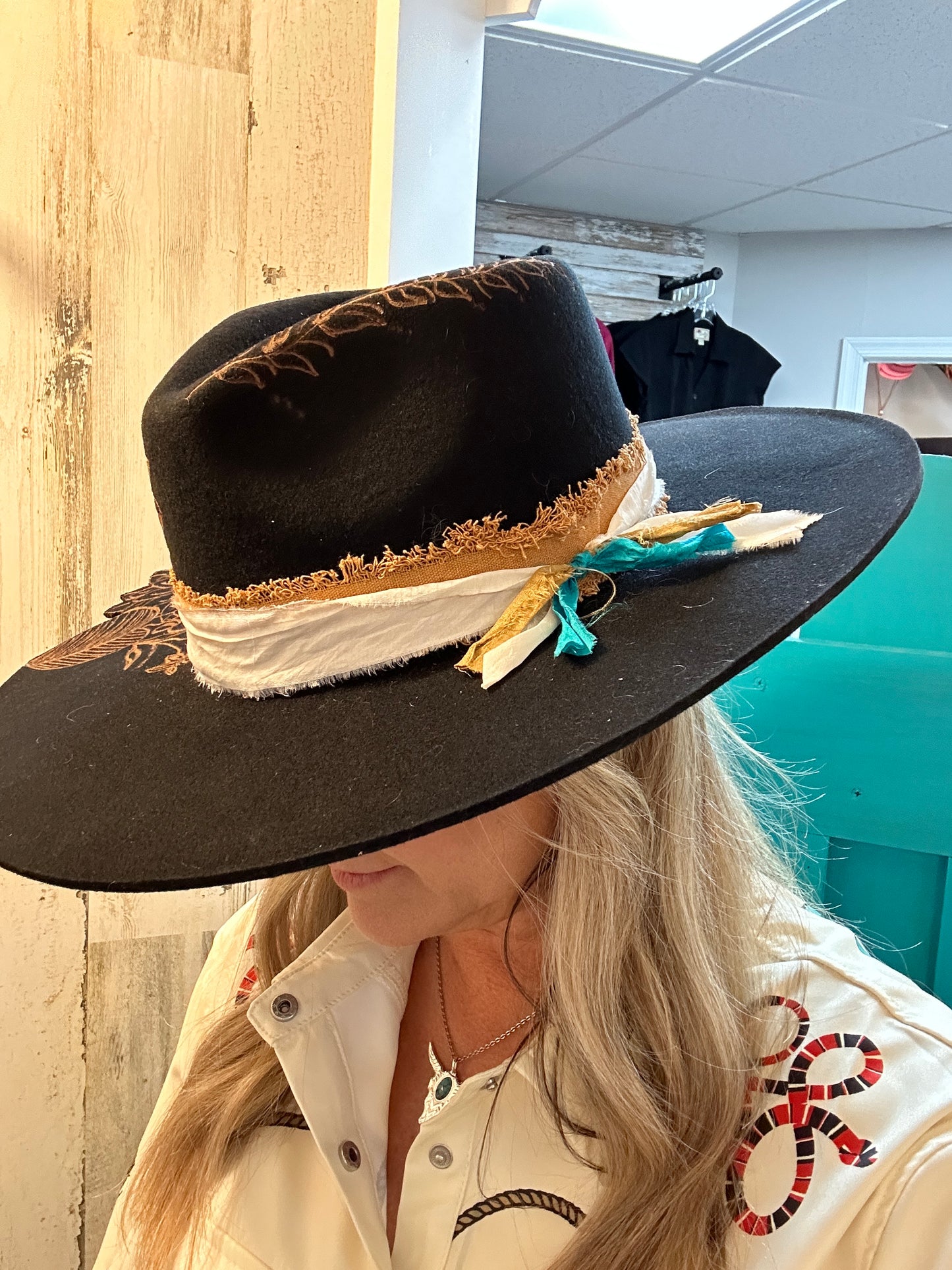 Woman wearing a black hat with decorative band.