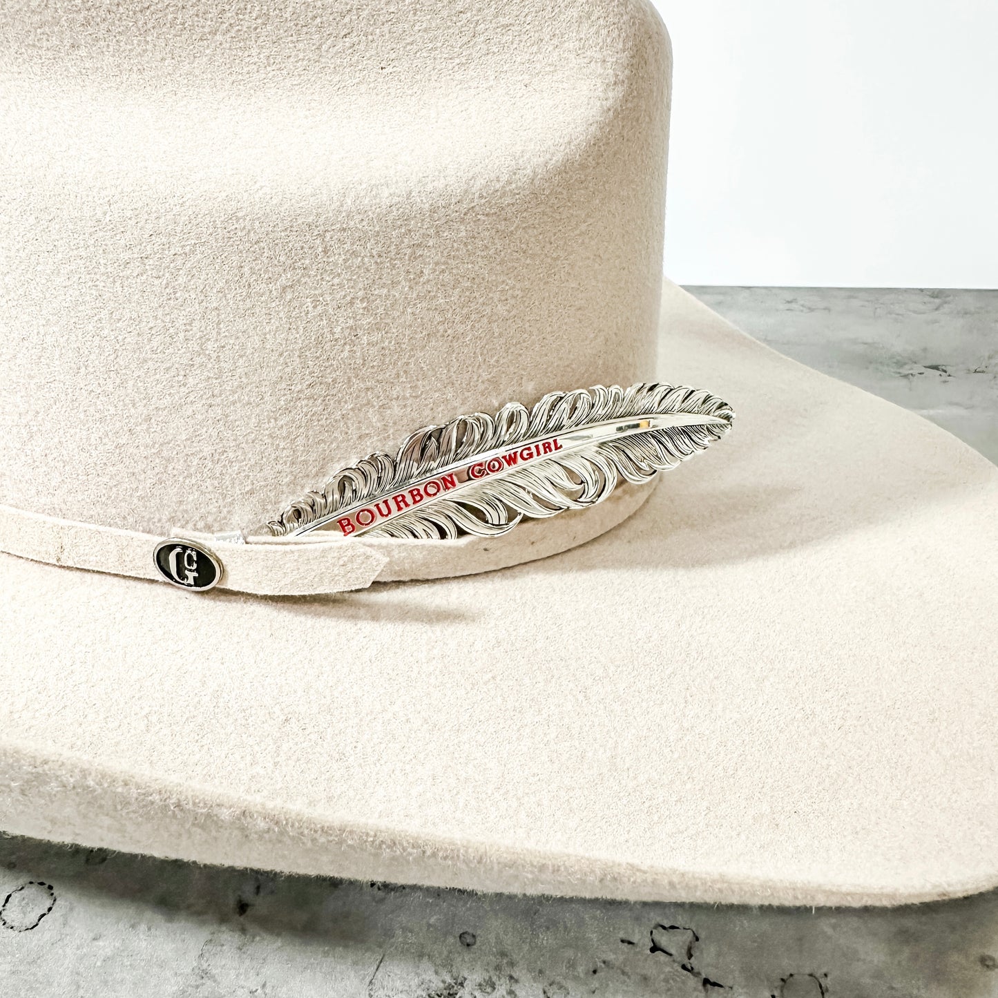 White cowboy hat with Bourbon & Bowties feather pin