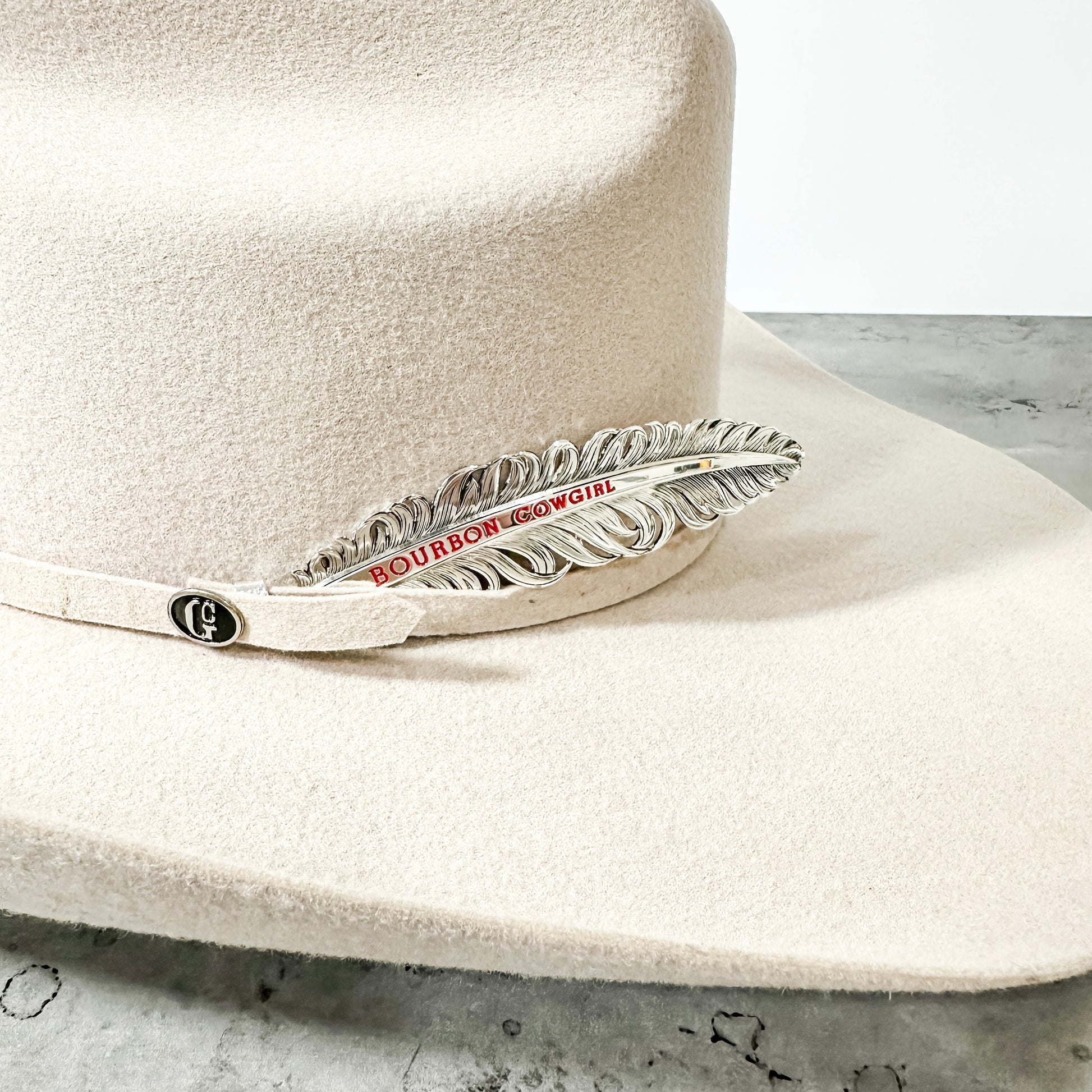 White cowboy hat with Bourbon & Bowties feather pin