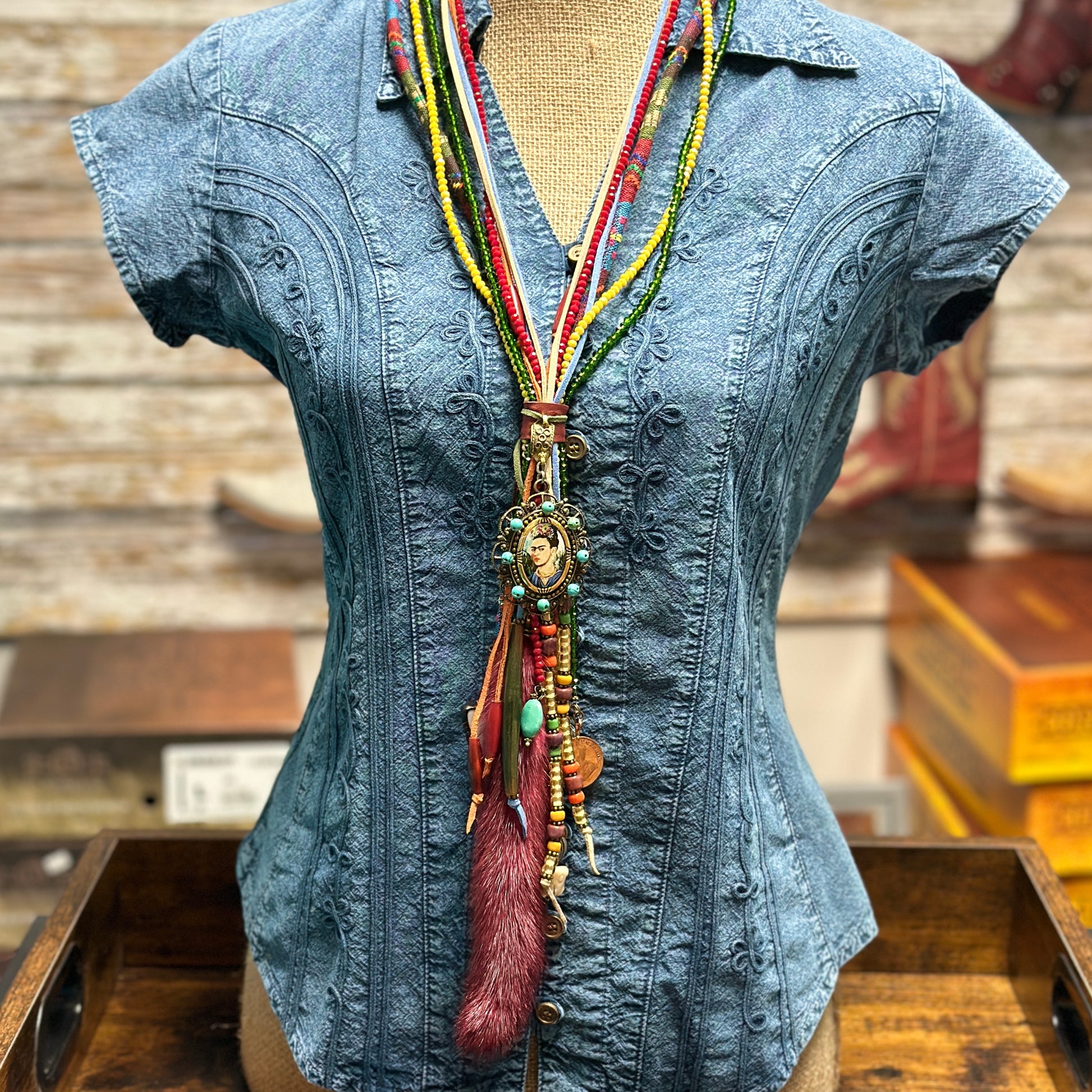 Blue denim shirt with colorful beaded necklace.