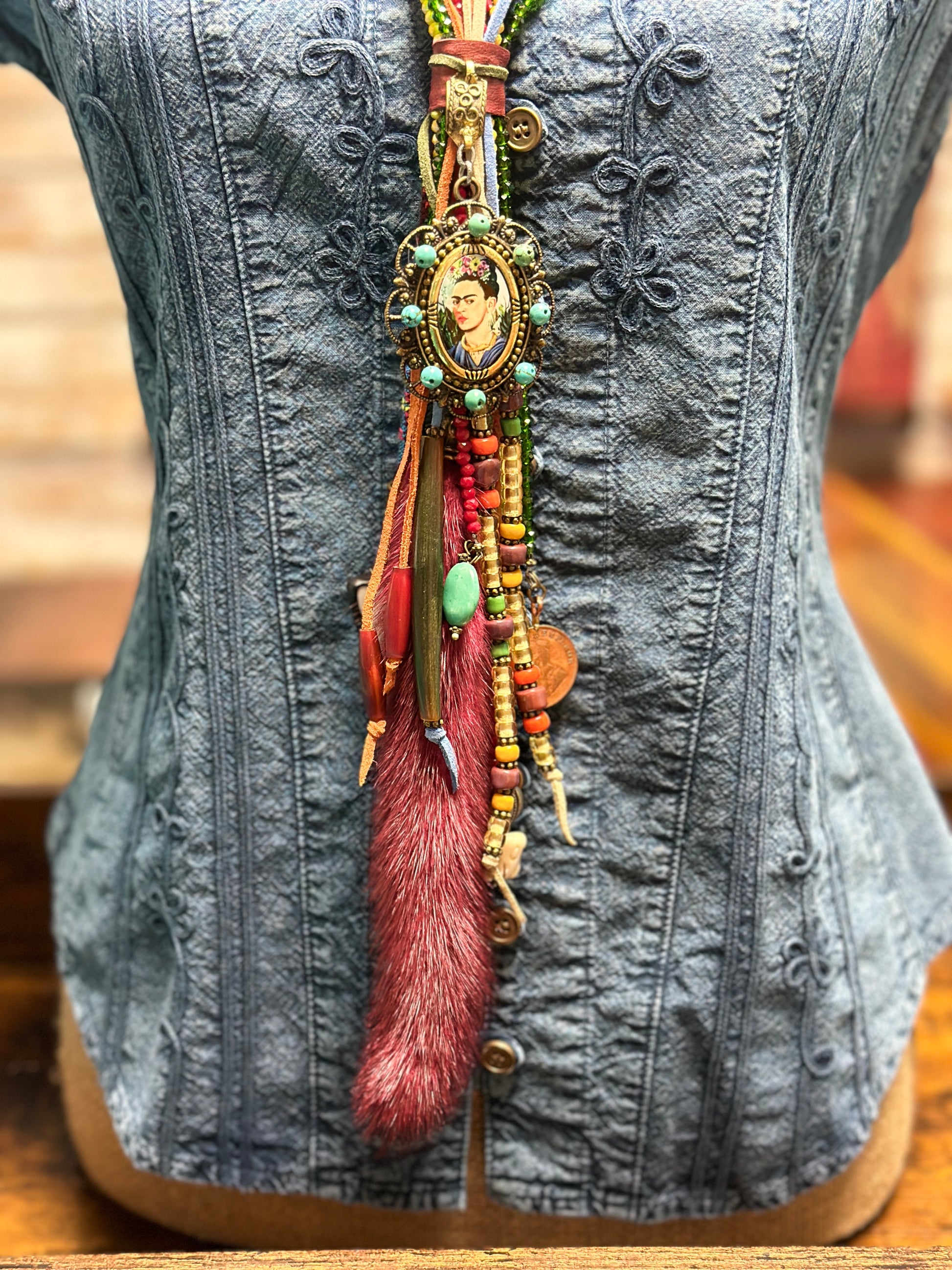 Denim top with ornate pendant necklace.