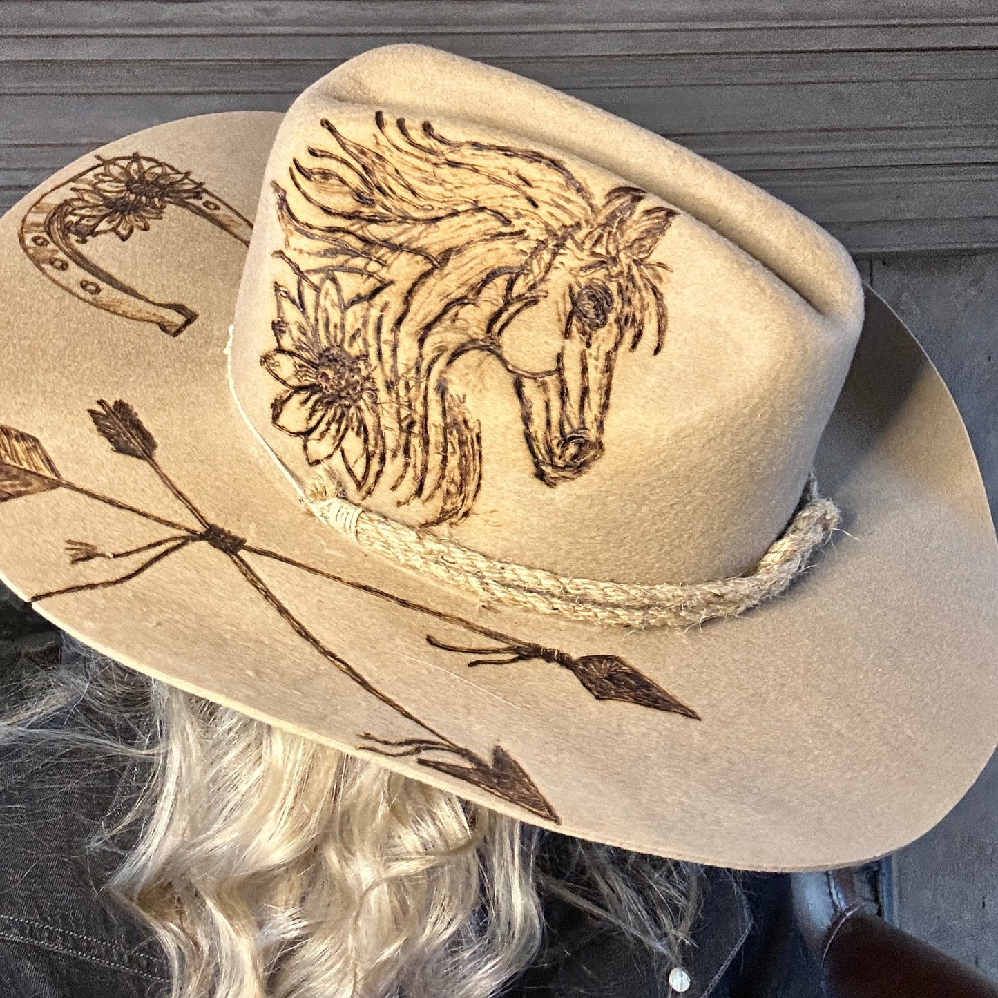 Cowboy hat with horse, arrows, and horseshoe design.
