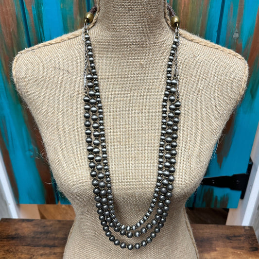 Three-strand beaded necklace on a mannequin.