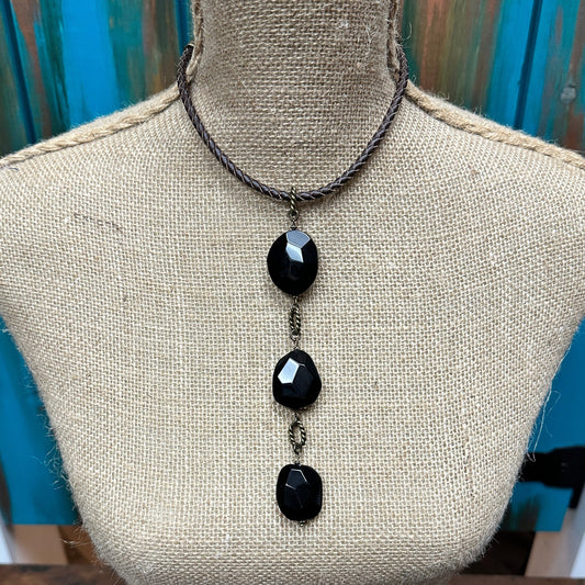 Black stone pendant necklace on a mannequin.
