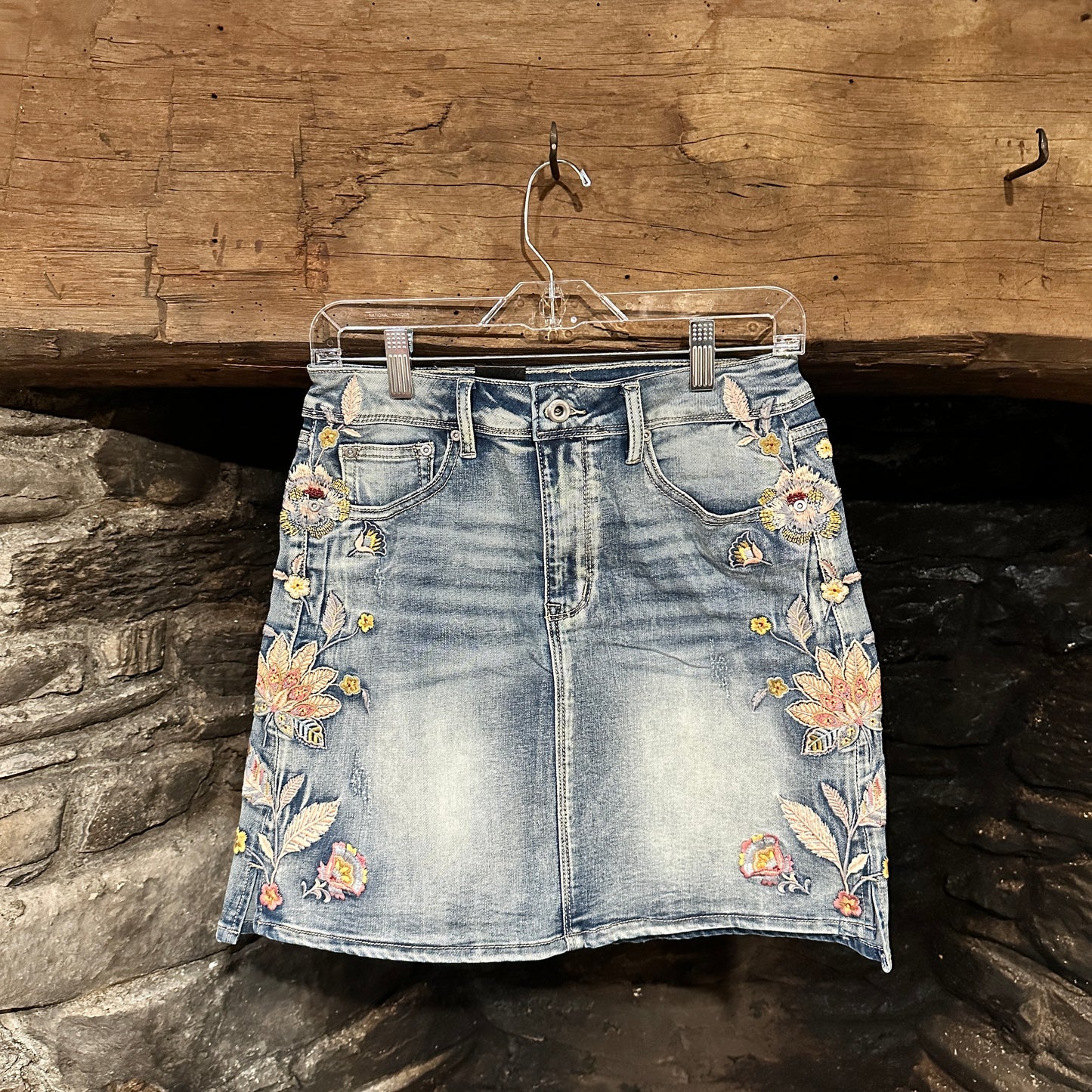 Denim mini skirt with floral embroidery.