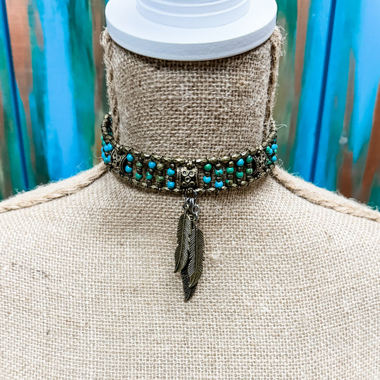 Beaded choker necklace with feather pendant.