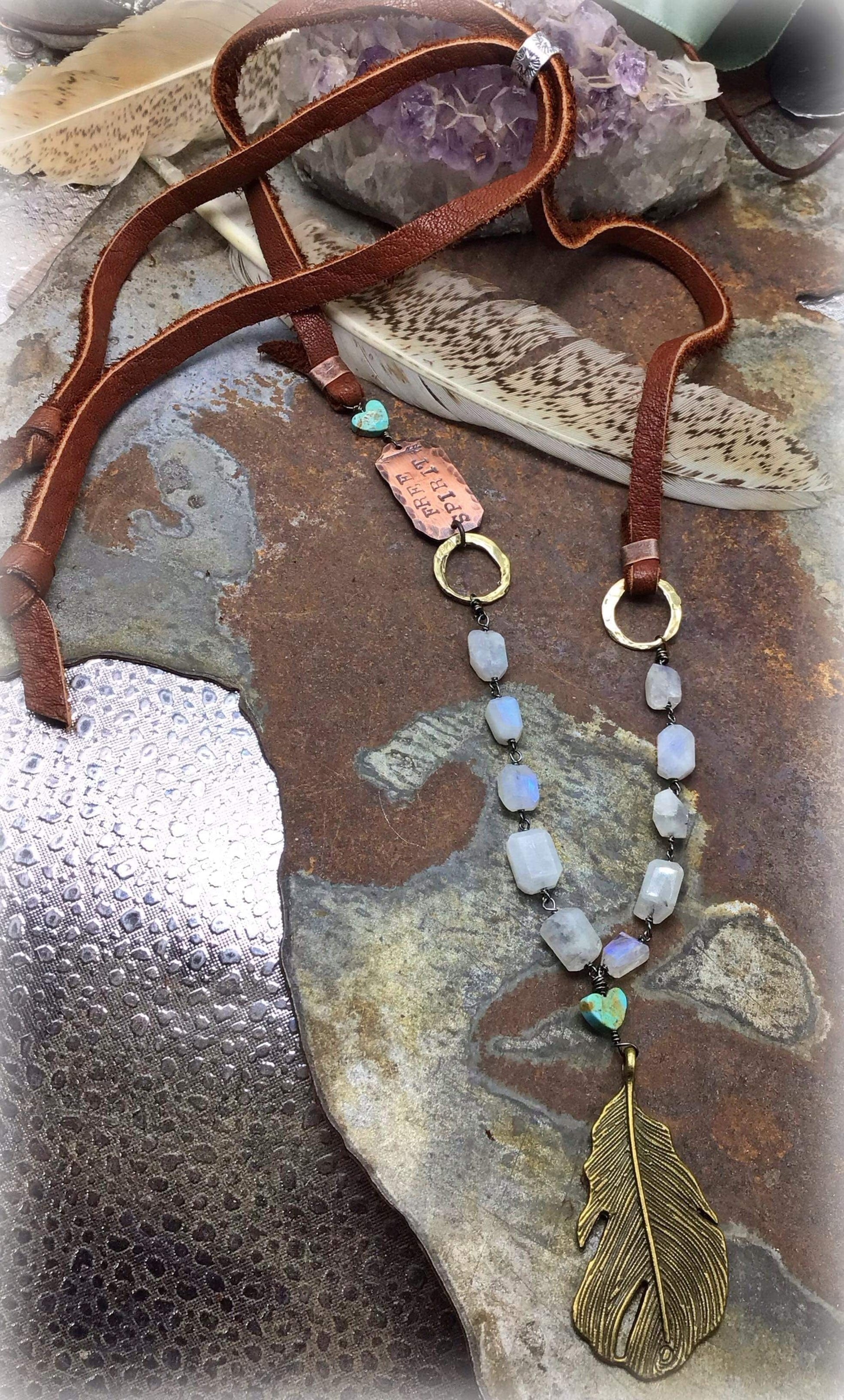 Leather necklace with stone beads and feather pendant.