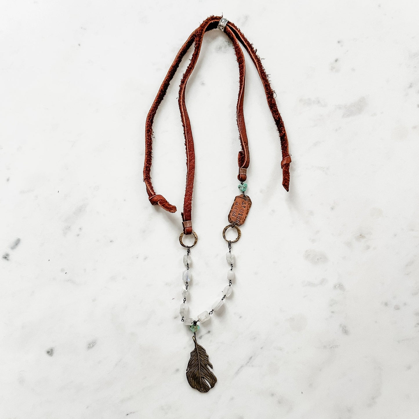 Leather and beaded necklace with feather pendant.