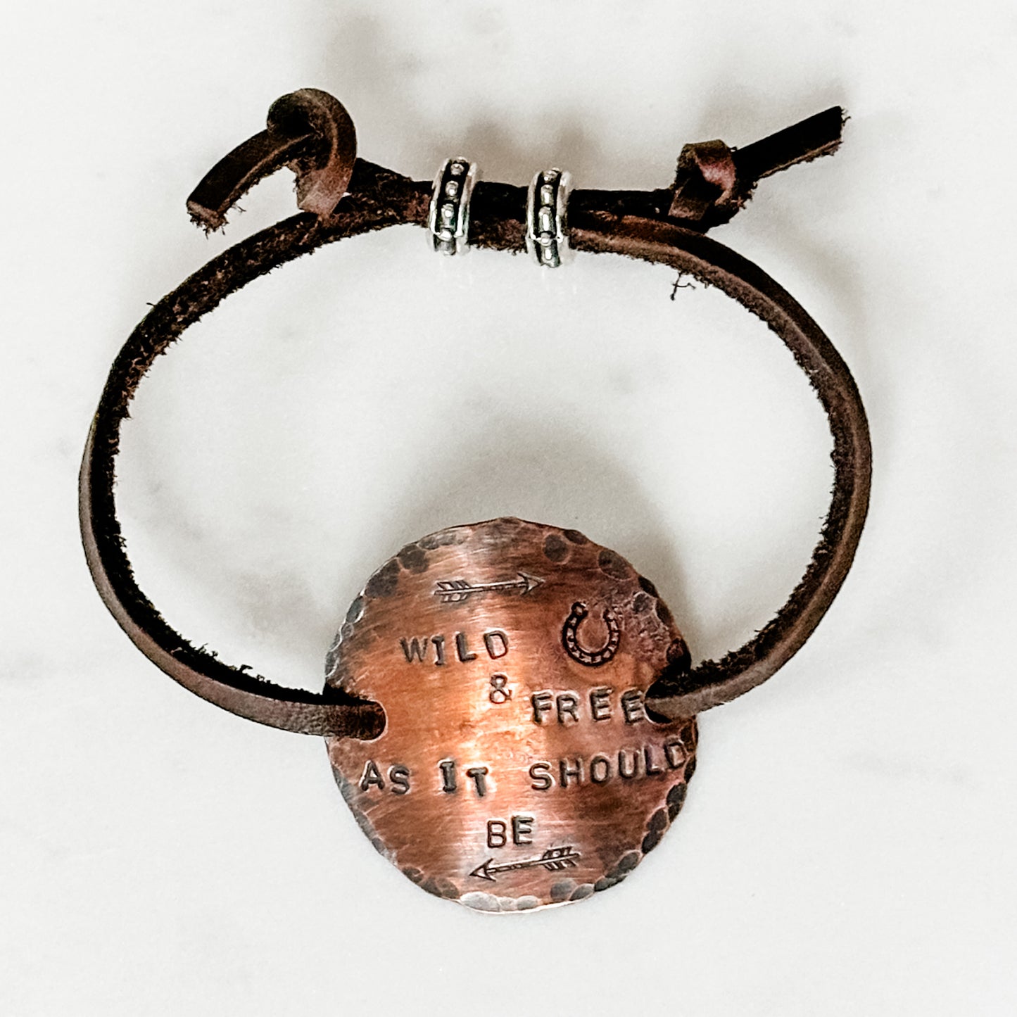 Leather bracelet with copper pendant.