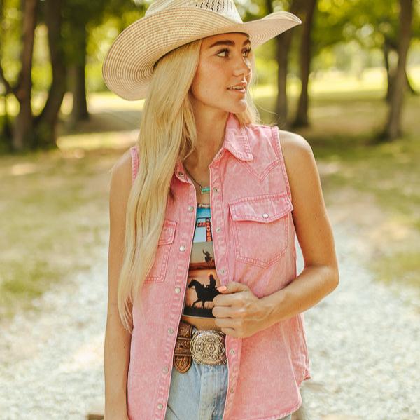 Woman in pink denim vest and cowboy hat.