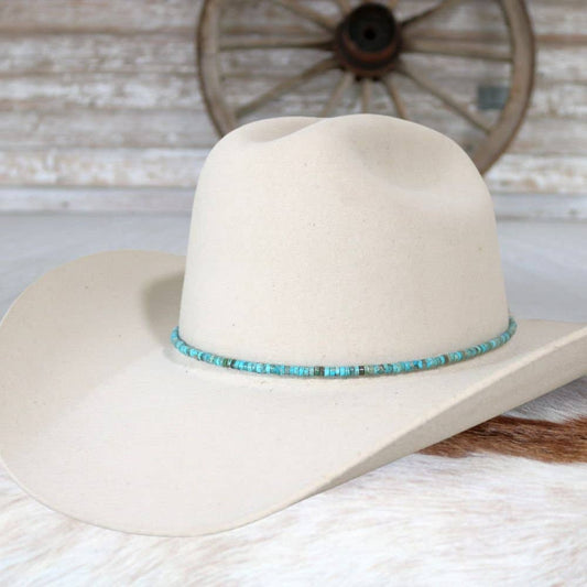 Cream-colored cowboy hat with turquoise beaded band.