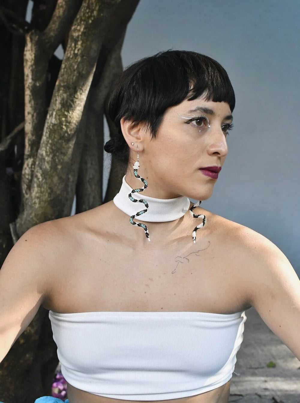 Woman wearing Athena snake earrings