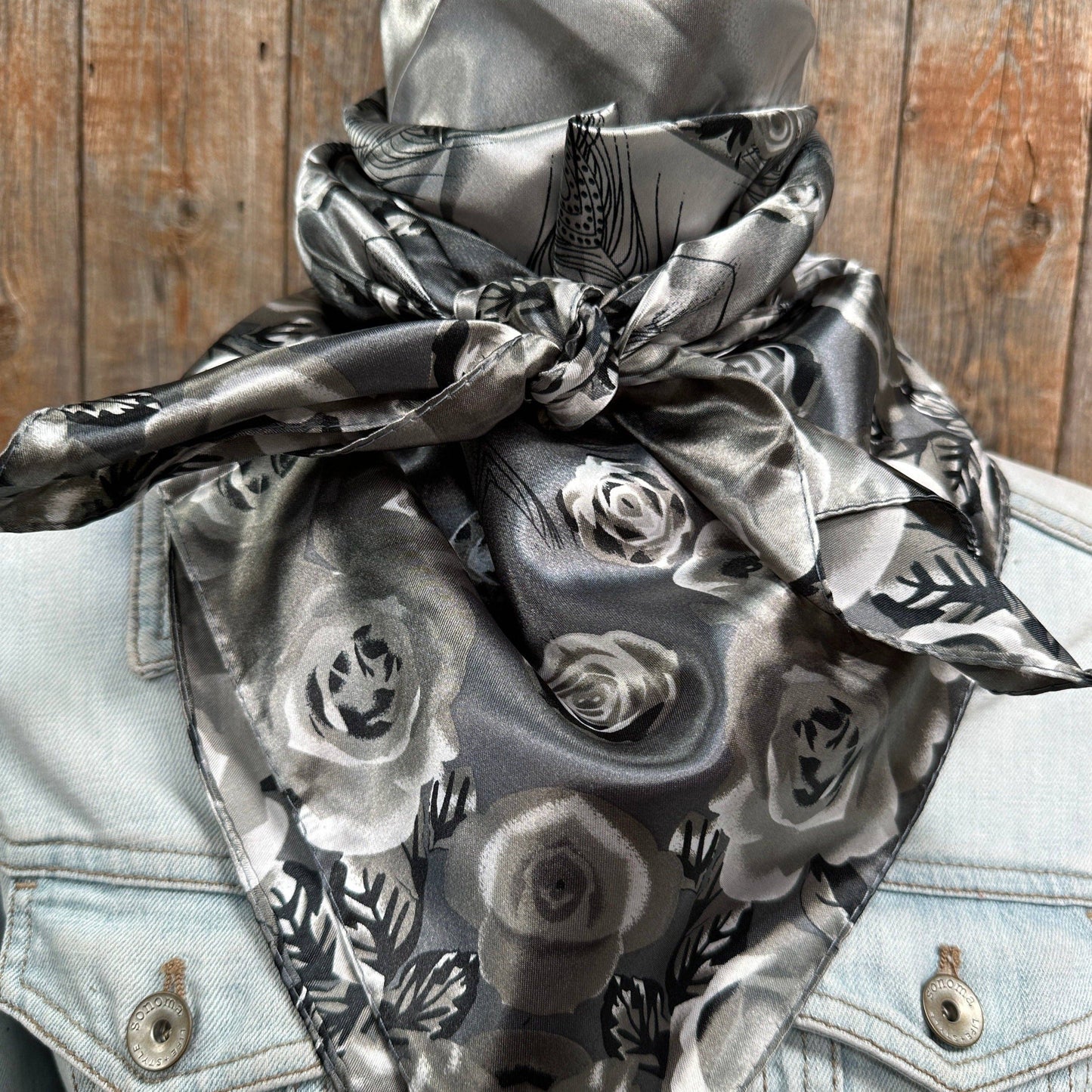 Gray floral scarf tied around neck.