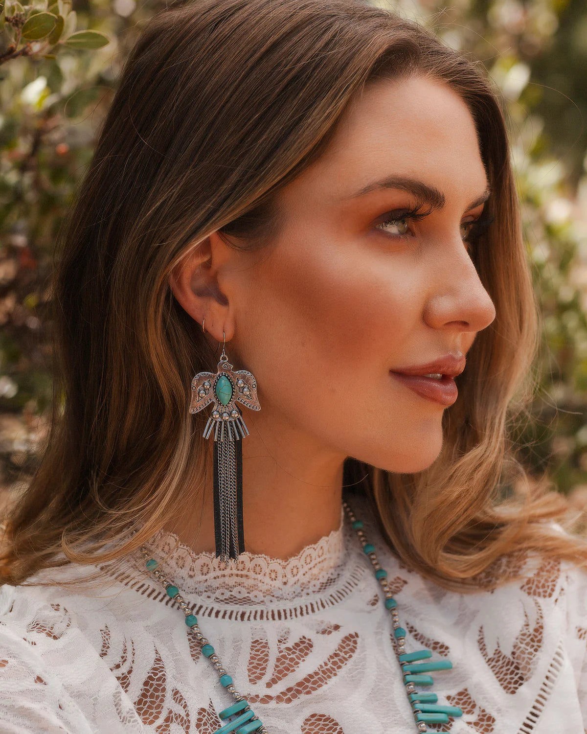 Woman wearing turquoise earrings, lifestyle image