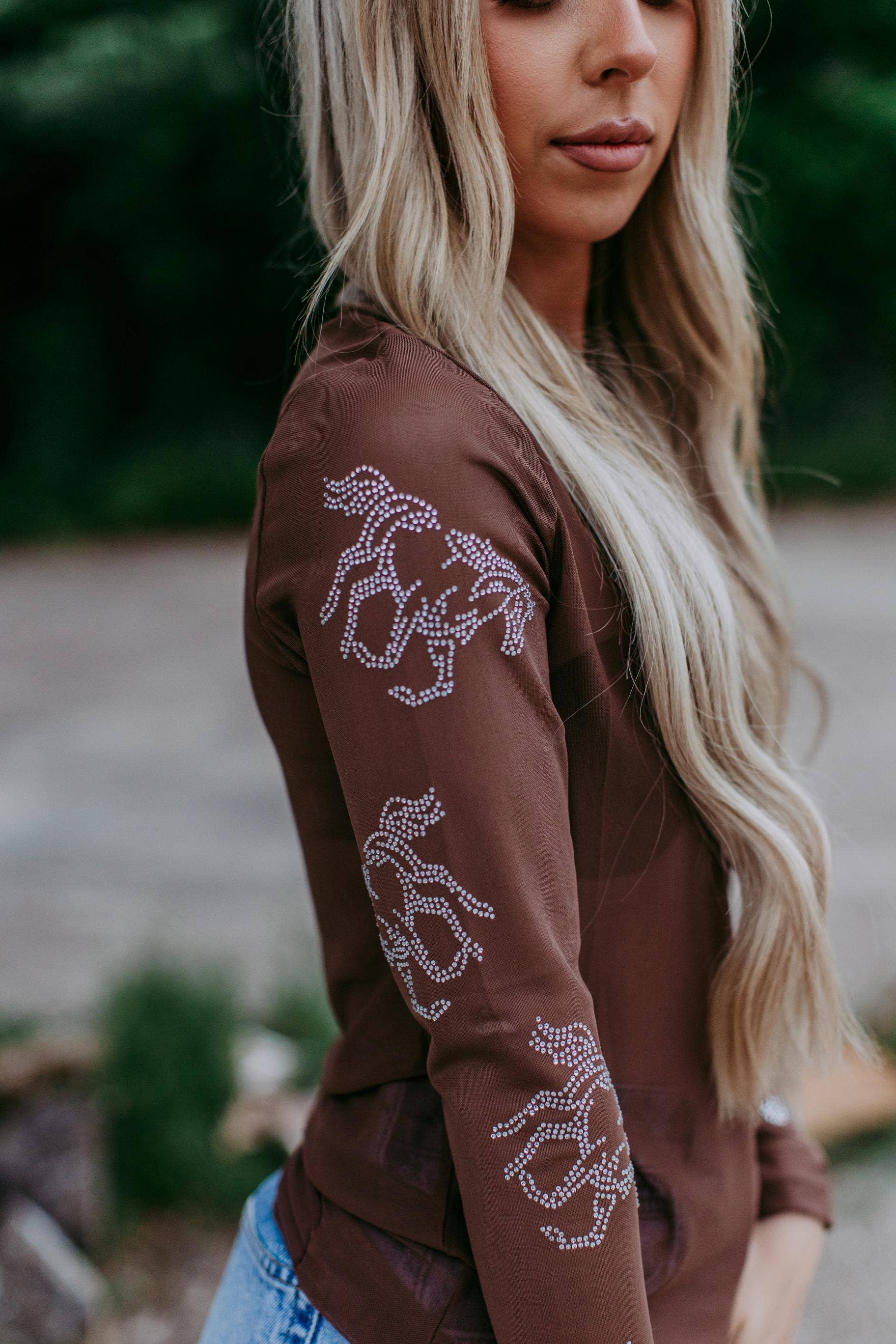 Woman in brown shirt with horse design