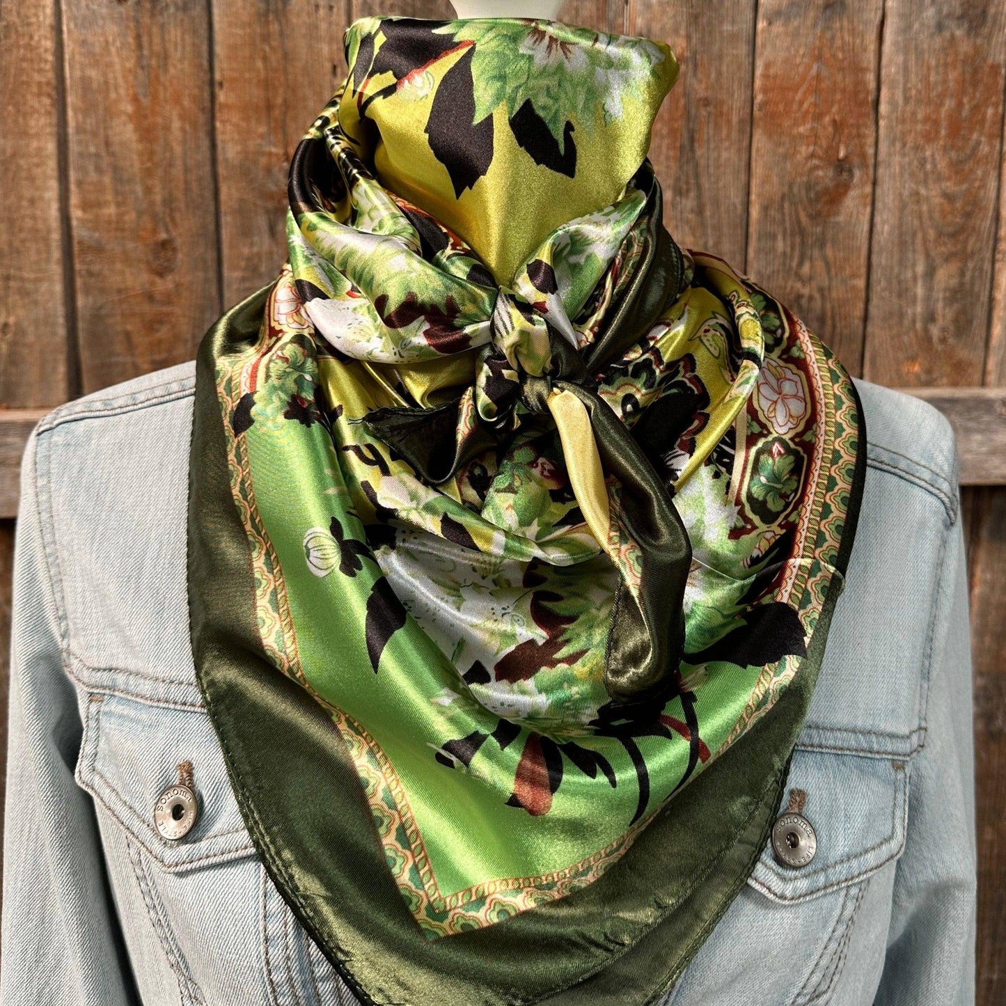 Green and yellow patterned silk scarf on denim jacket.