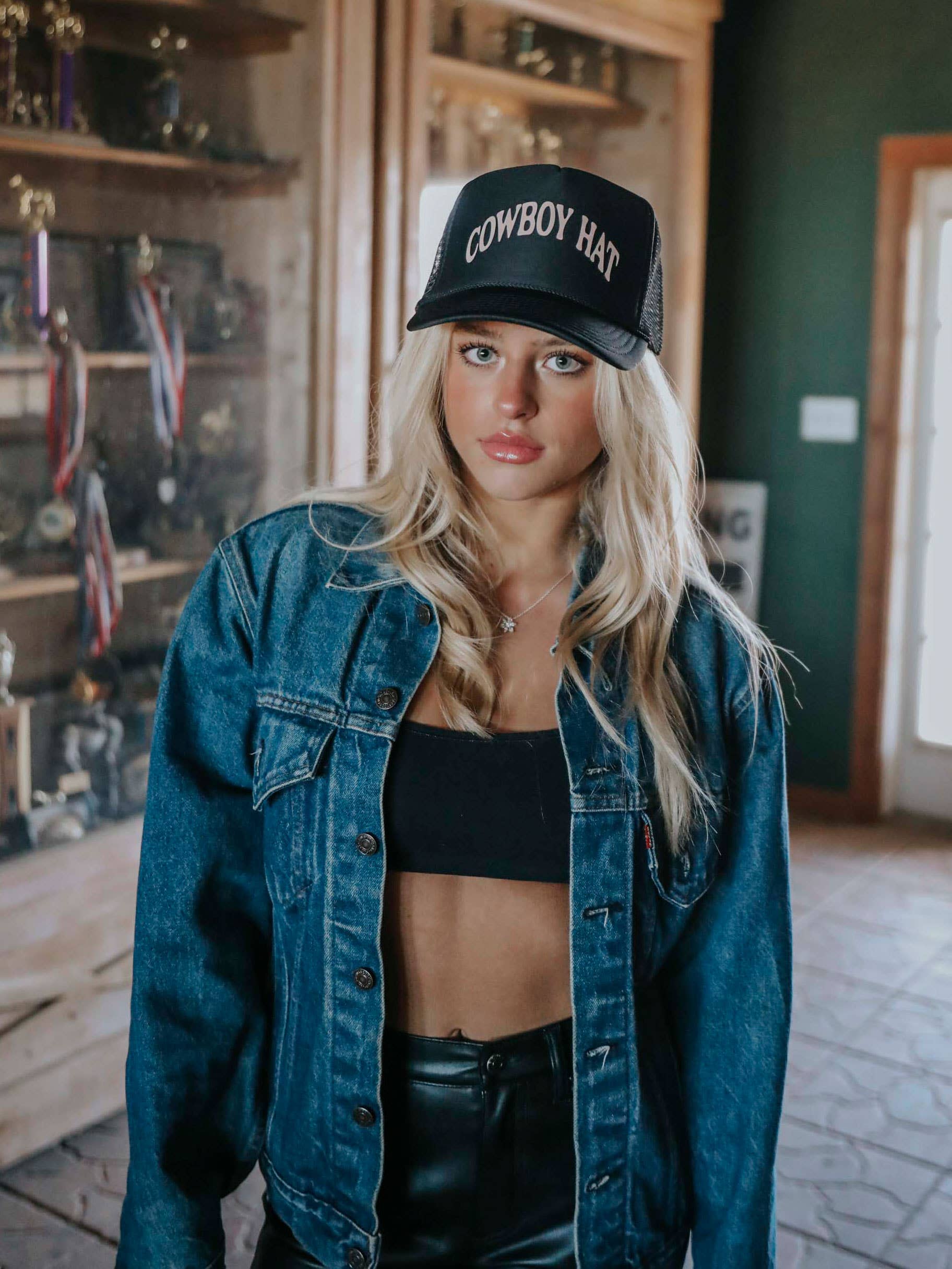 Woman in denim jacket and Cowboy Hat cap.