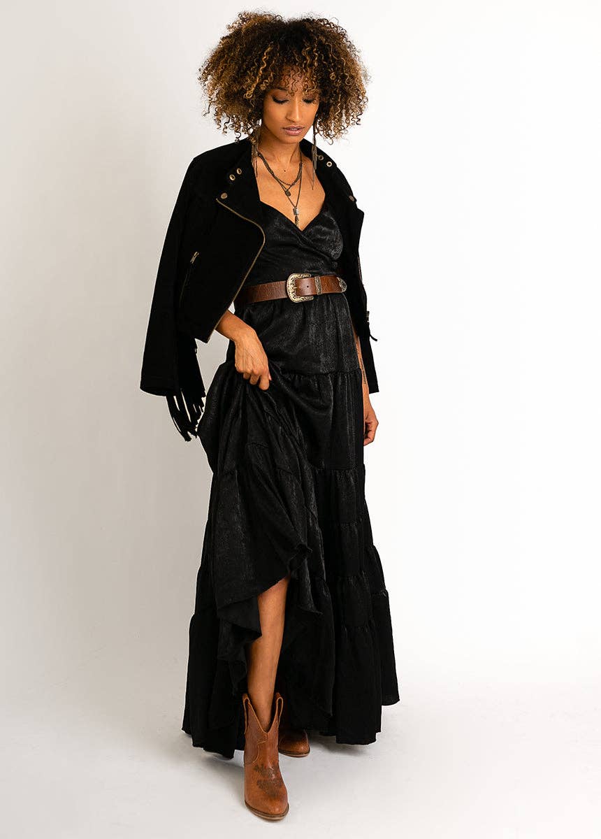 Woman in black dress and jacket with cowboy boots.