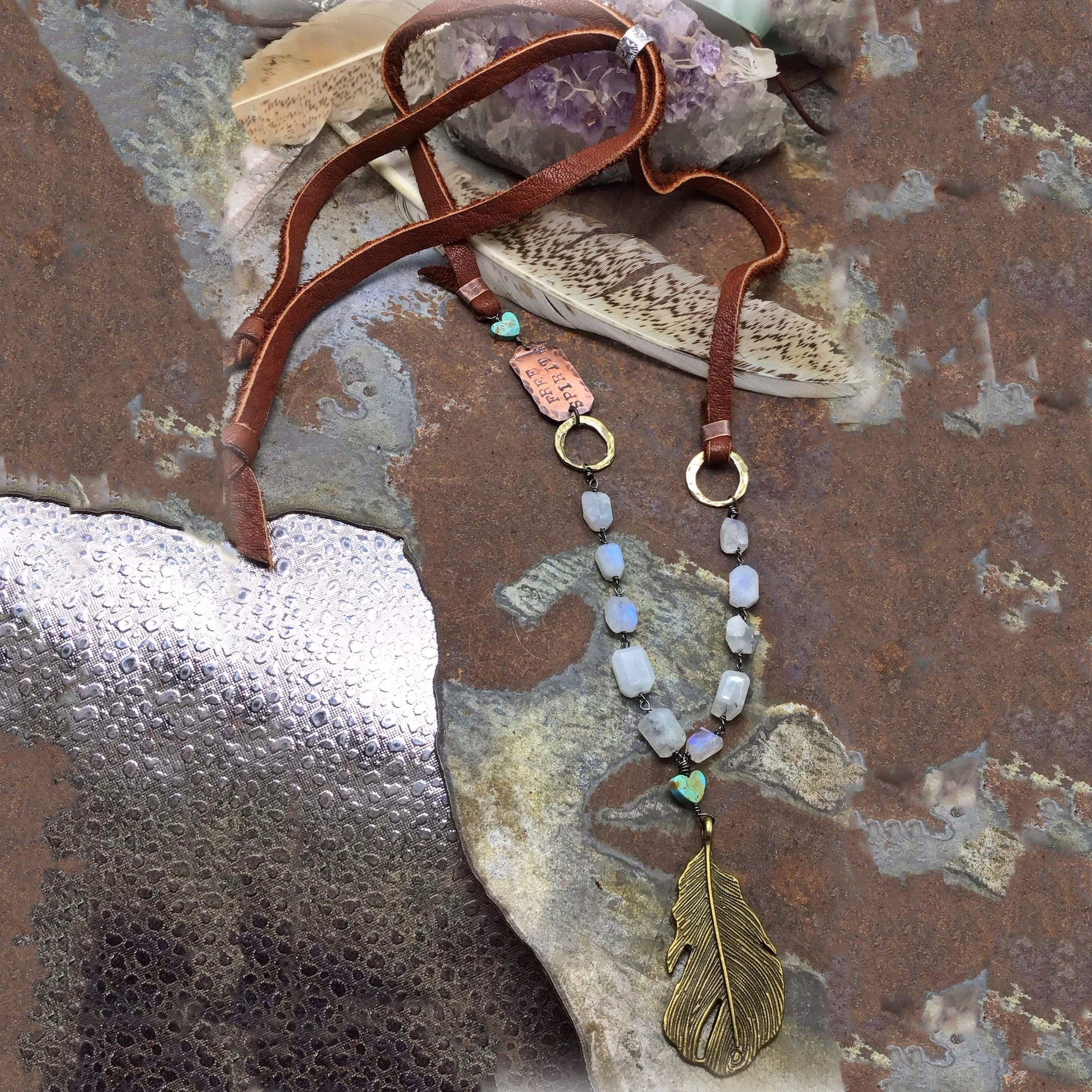 Feather necklace with stone beads on a square background