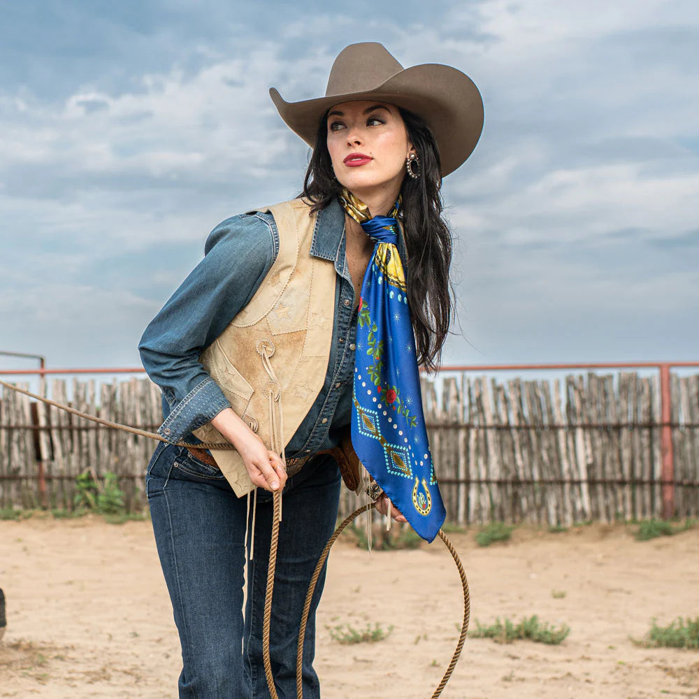 Cowgirl in royal blue wild rag scarf, holding rope