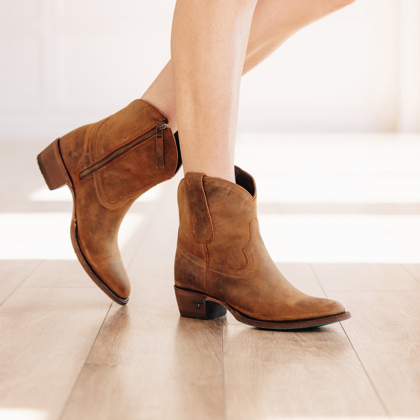 Burnt caramel Plain Jane booties on wooden floor