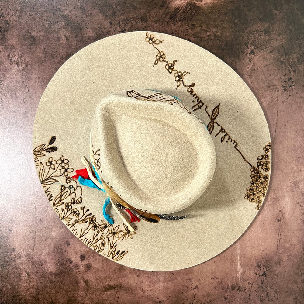 Tan bronze hat with floral and wild thing design