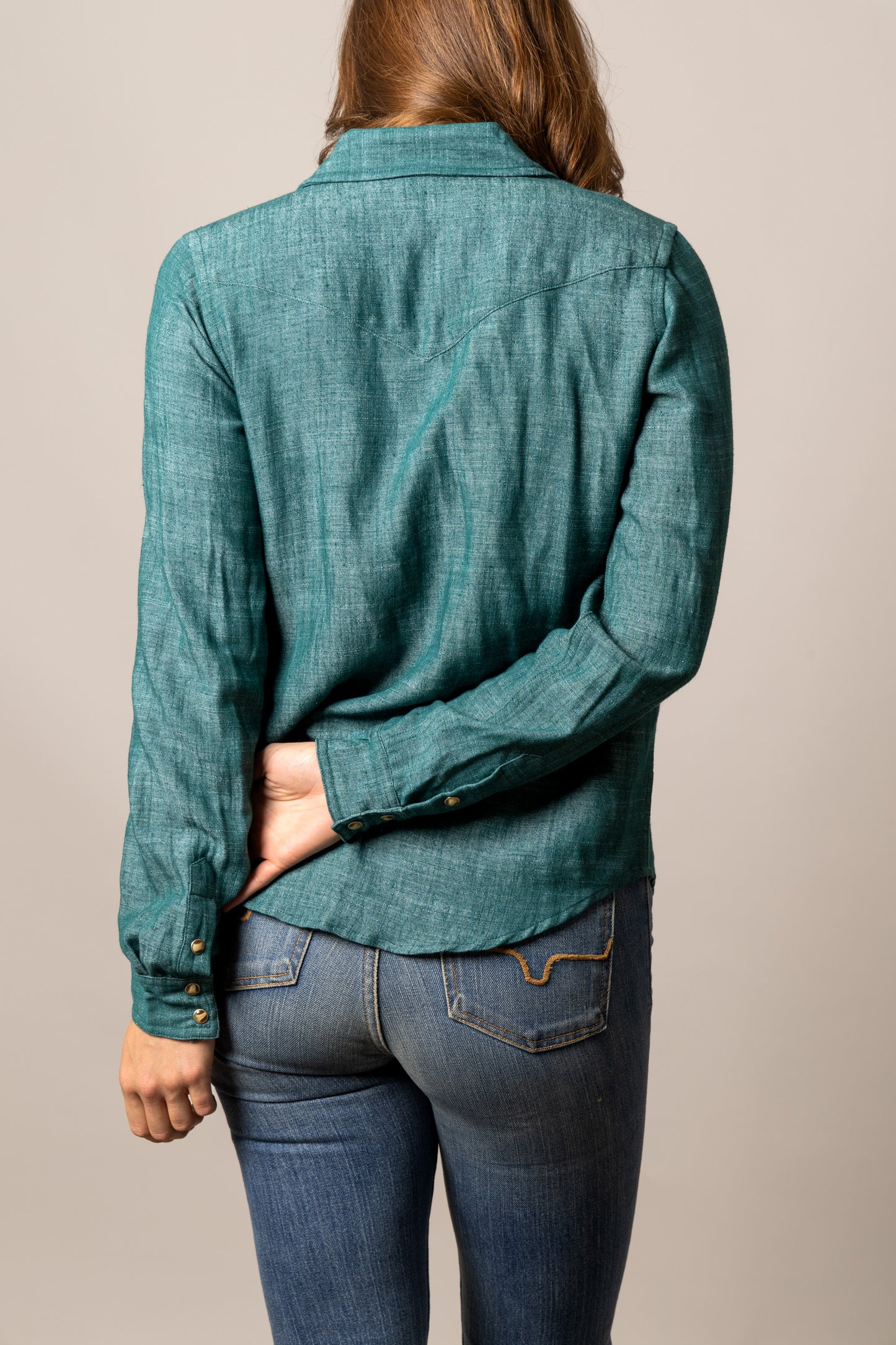 Woman wearing a teal button-up shirt and jeans, unnamed-227