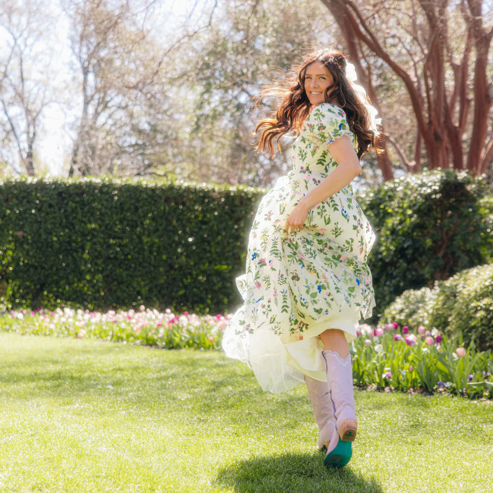 Woman in floral dress running outdoors.