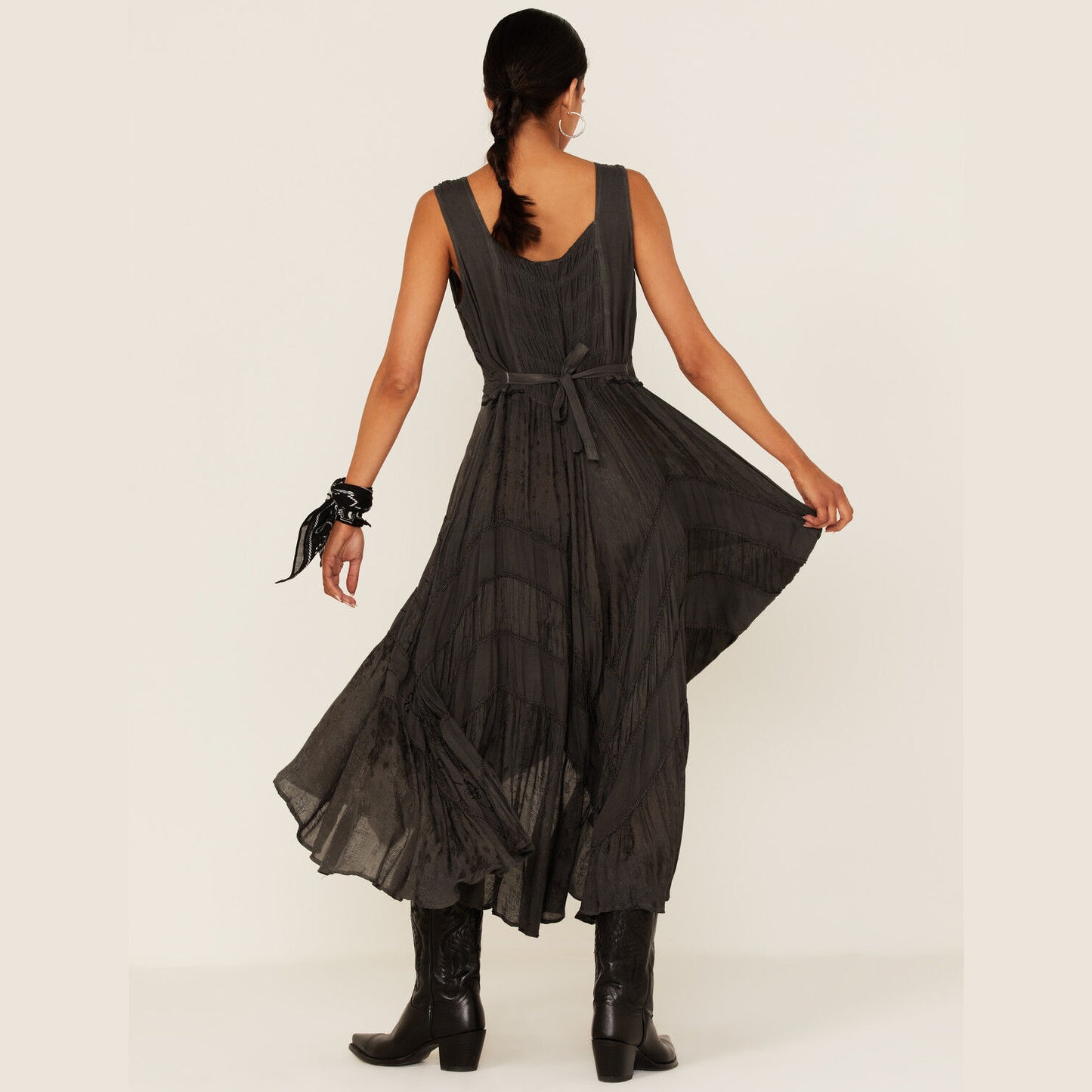 Woman in dark dress and boots, back view.