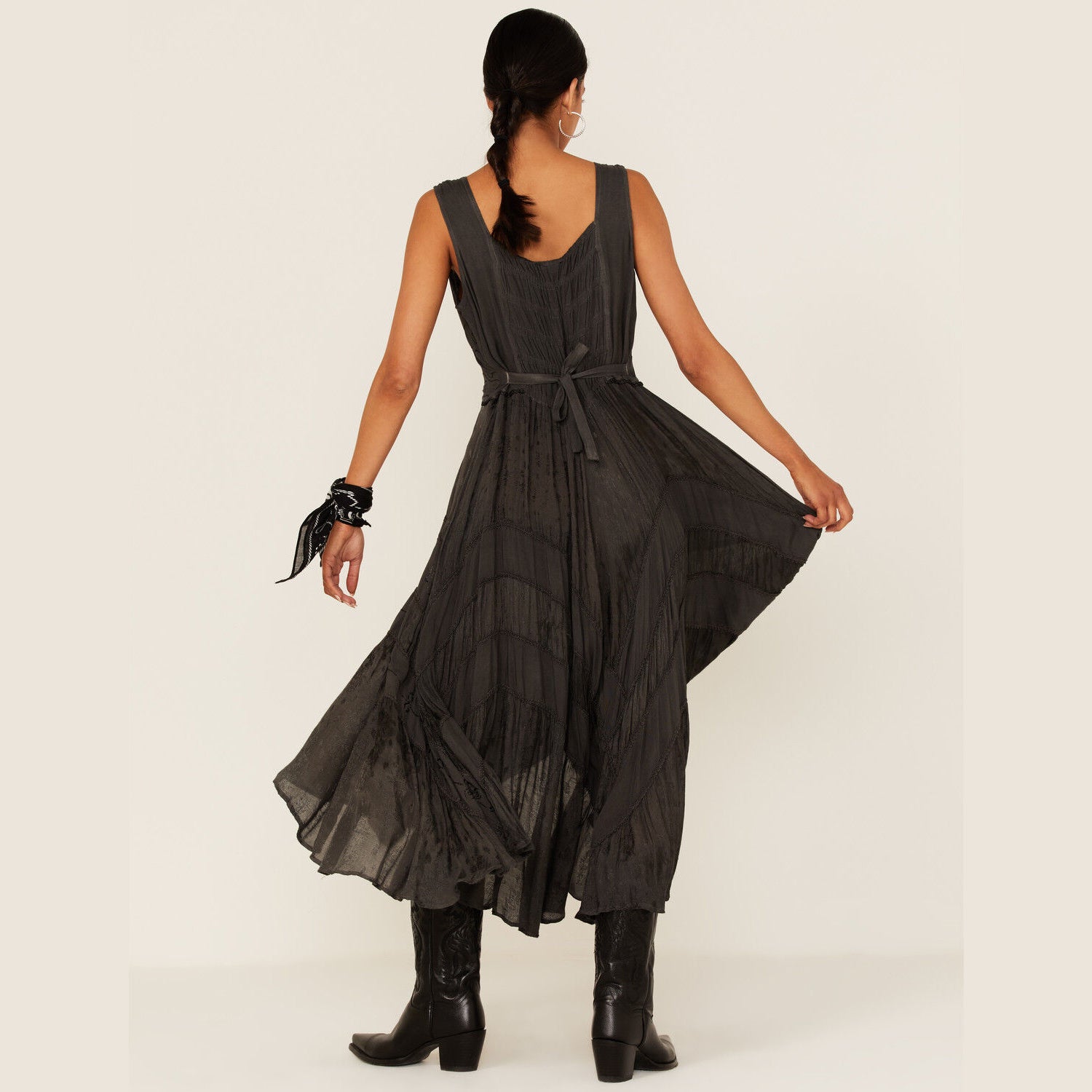Woman in dark dress and boots, back view.