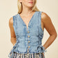 Woman wearing a denim vest.