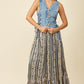 Woman in denim vest and long patterned skirt.