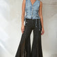 Woman wearing denim vest and black flared pants.