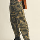 Person wearing camouflage pants and boots.